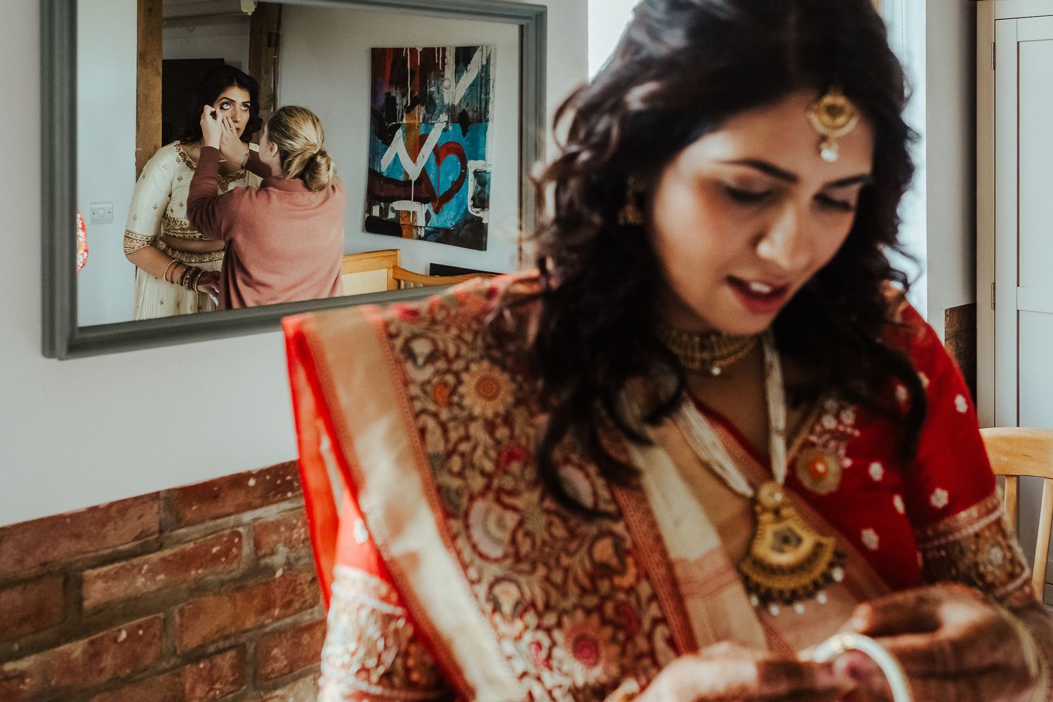 Wedding preparations scene with ornate red sari and mirrors reflecting the getting-ready process.
