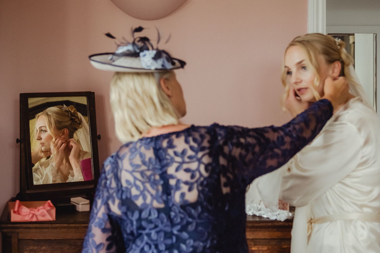 A bride and bridesmaids prepare for a wedding celebration in a room with a warm, natural light setting.