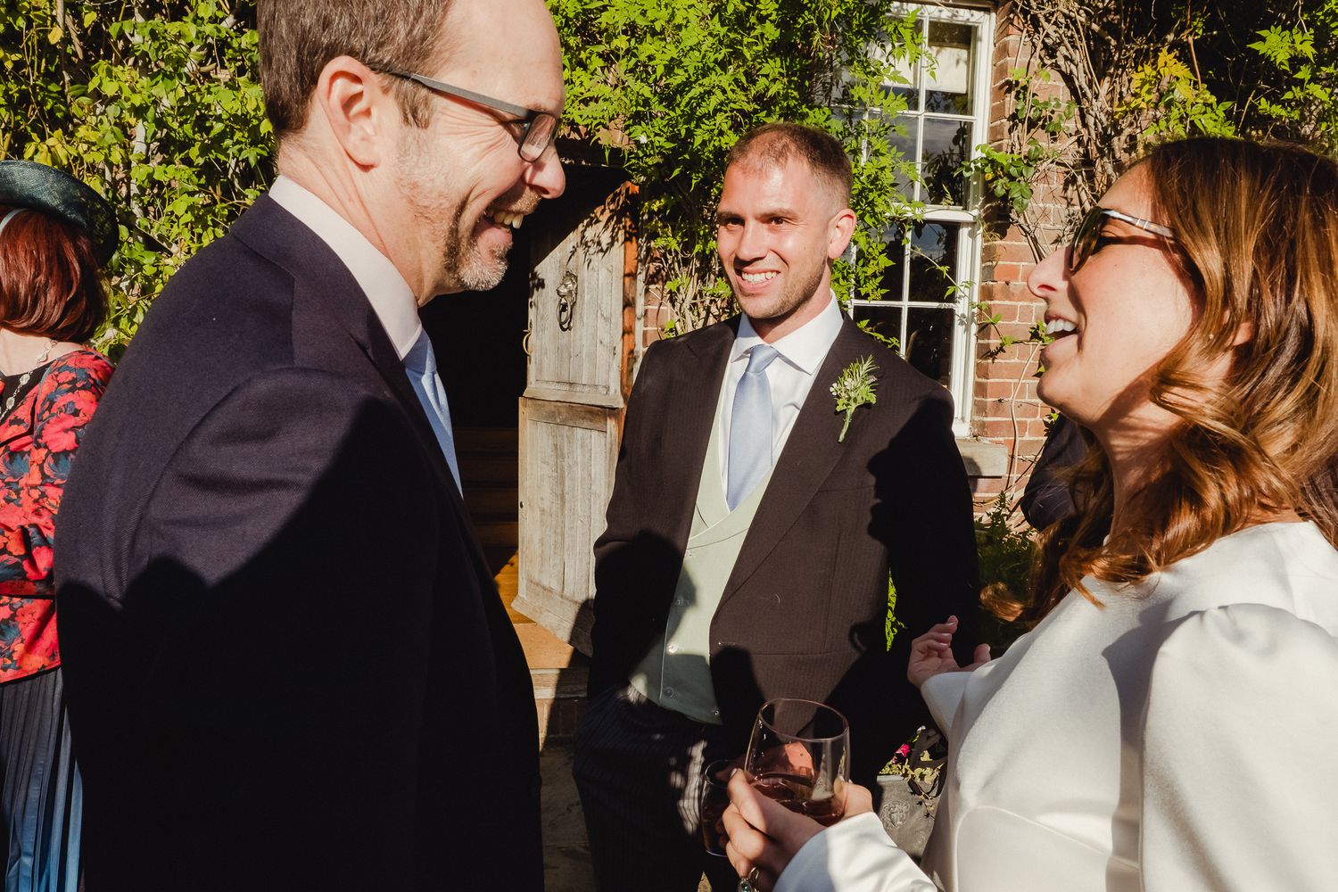 Candid moments from an outdoor wedding celebration showing guests mingling and socializing in a garden setting.