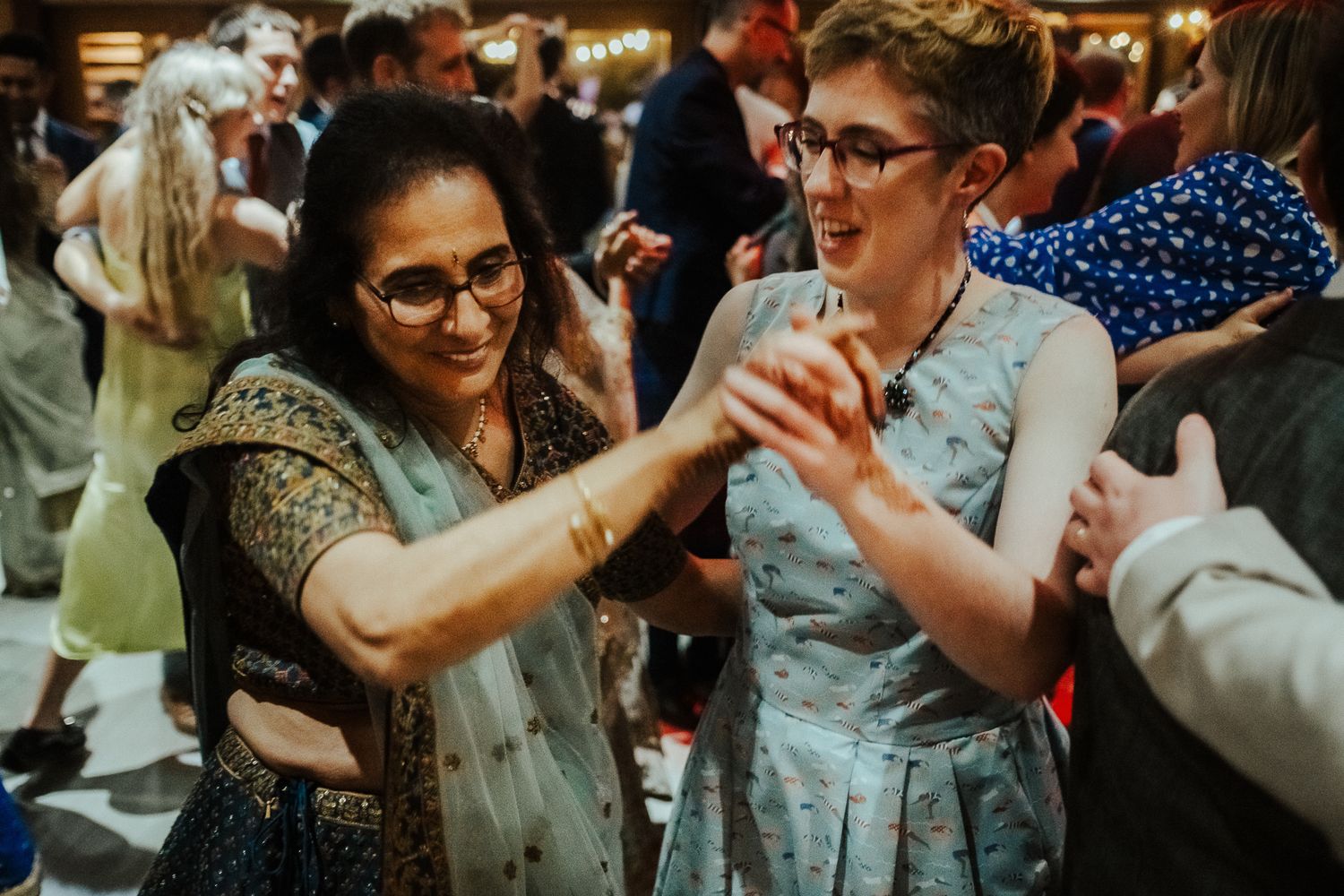 Wedding guests dancing and enjoying themselves at a fusion cultural celebration.