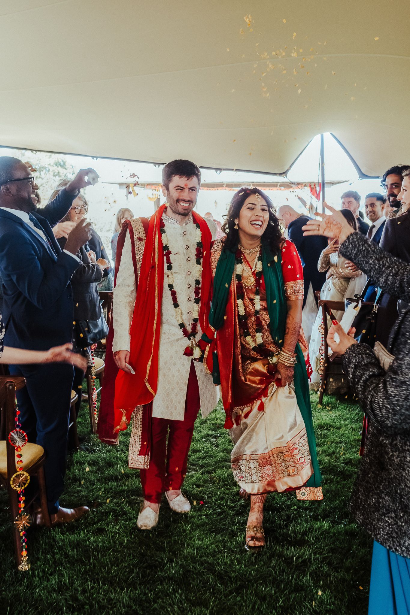 Guests celebrate with sparklers during a joyful fusion wedding reception outdoors.