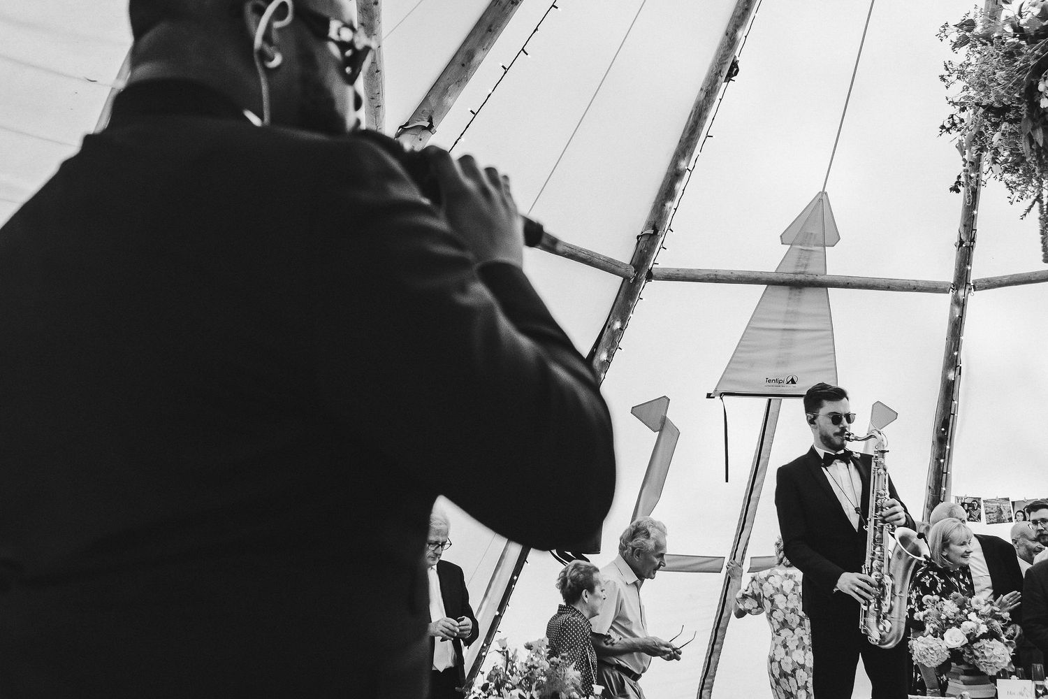 Black and white reception photos showing guests dancing and celebrating under a tent.