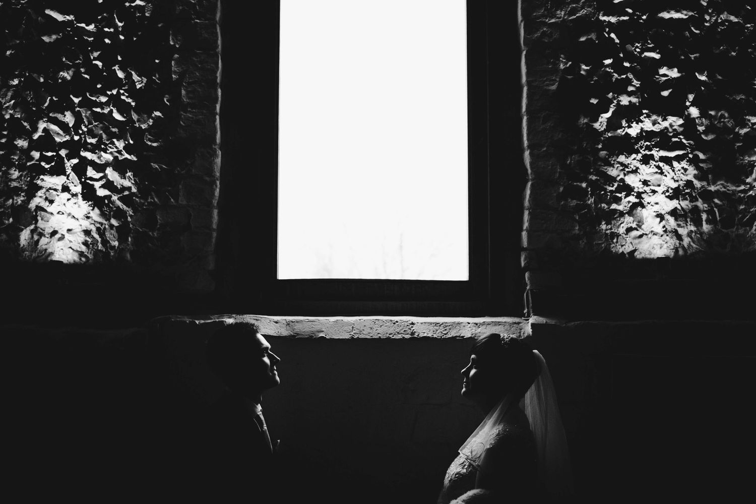 Artistic silhouette of a window frame against contrasting dark walls.