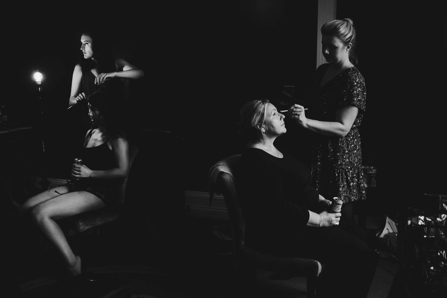 Dramatic black and white shot of wedding preparation in dark room.