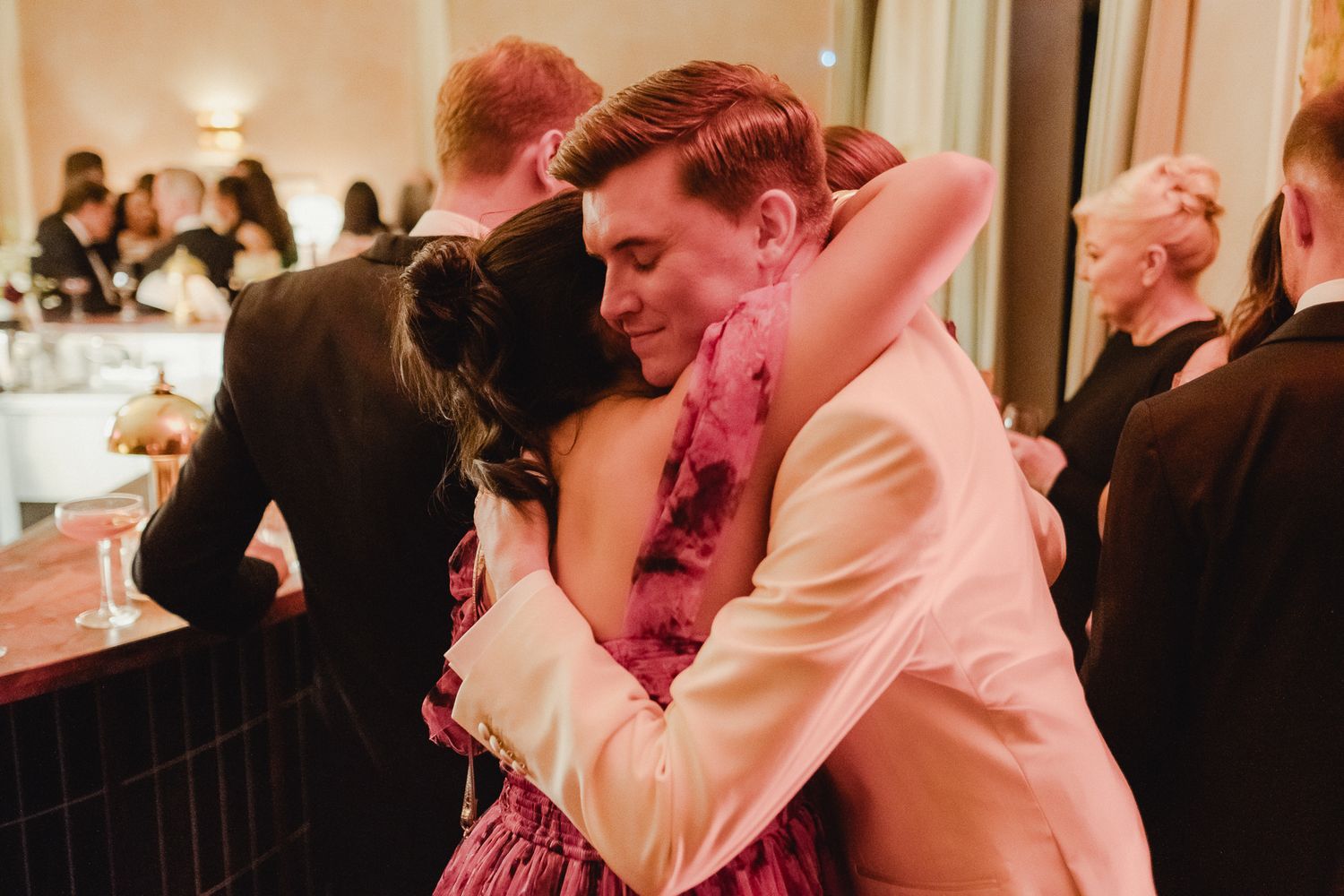 Couples dance together at an elegant wedding reception under warm lighting.