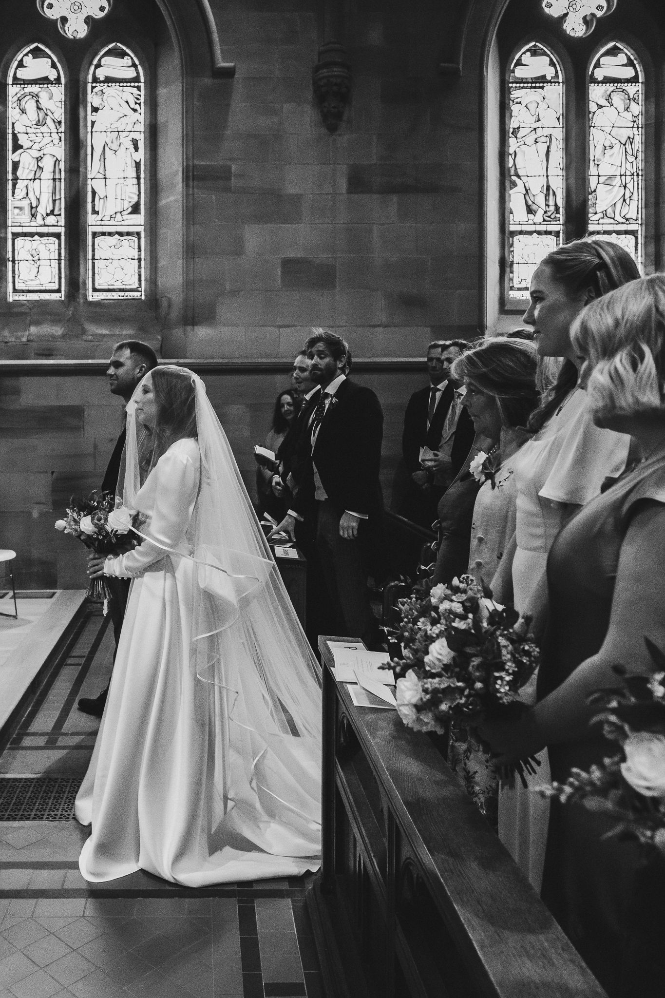 Black and white photo sequence showing a bride walking down the church aisle in an elegant white gown during a wedding ceremony.