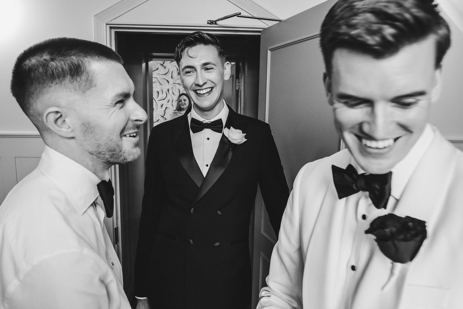 A group of people in formal attire share joyful moments while getting ready for a wedding celebration.
