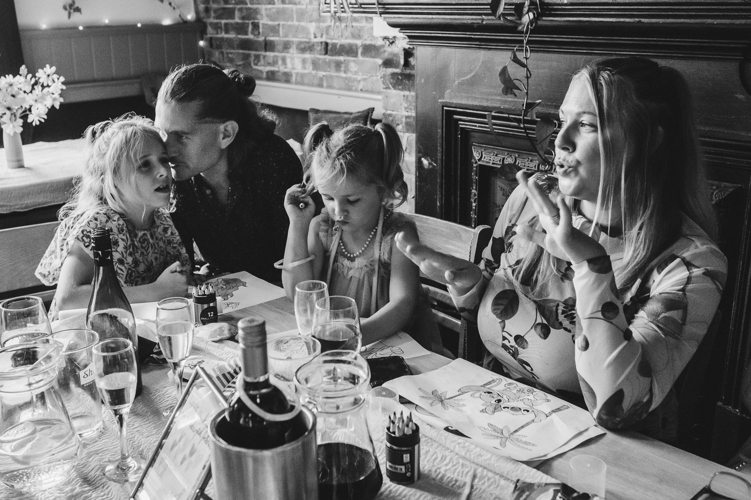 People sit at tables in a restaurant enjoying meals and drinks while engaging in conversation and laughter.