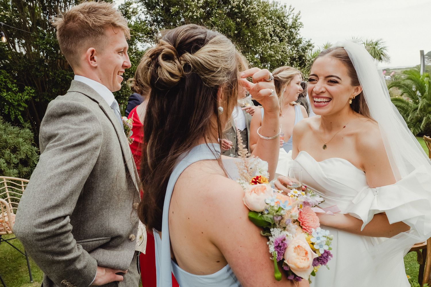 Wedding guests and the newlyweds share joyful moments during outdoor wedding celebration.