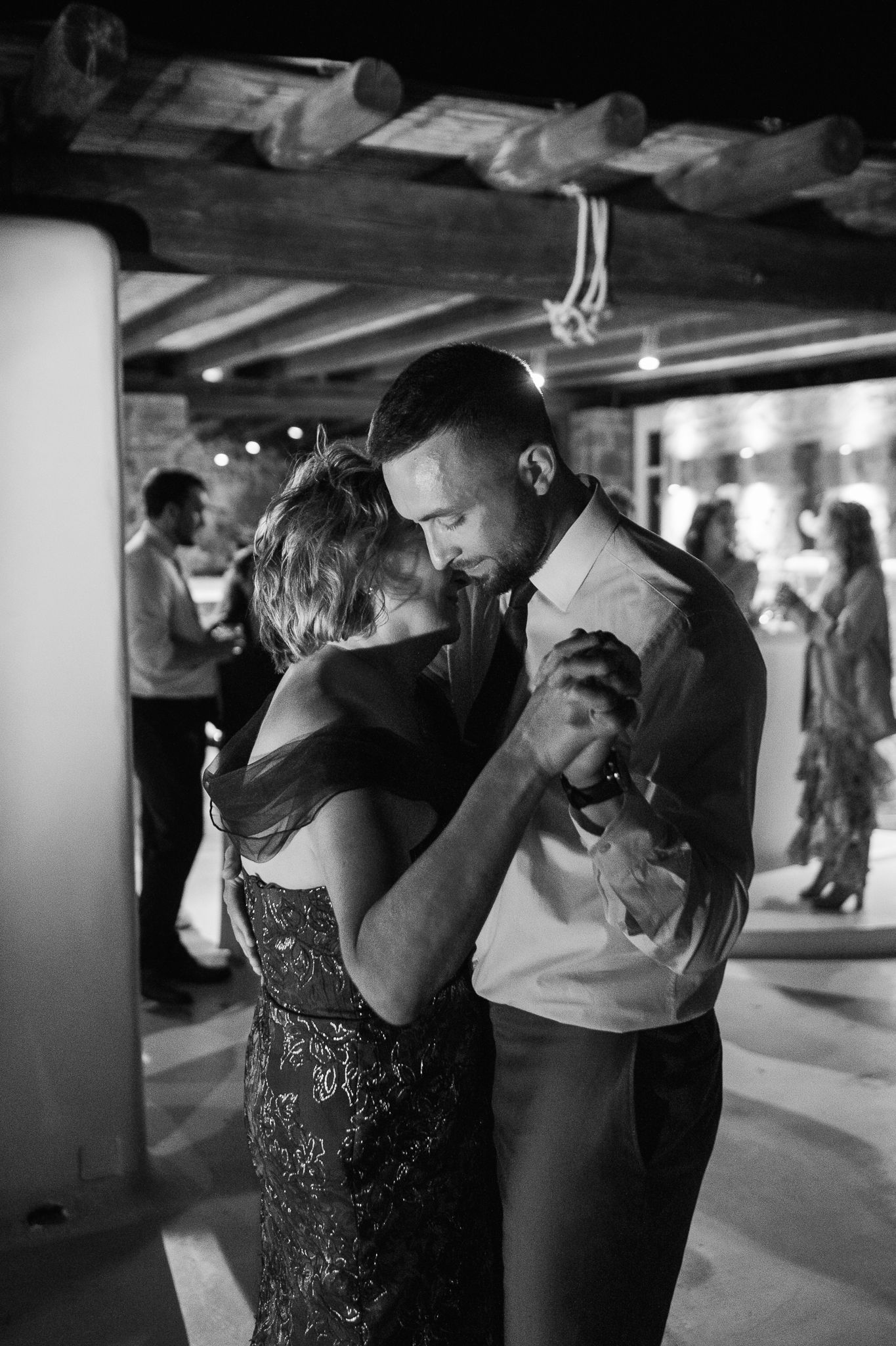 Couple sharing an intimate slow dance at a wedding reception in black and white photography.
