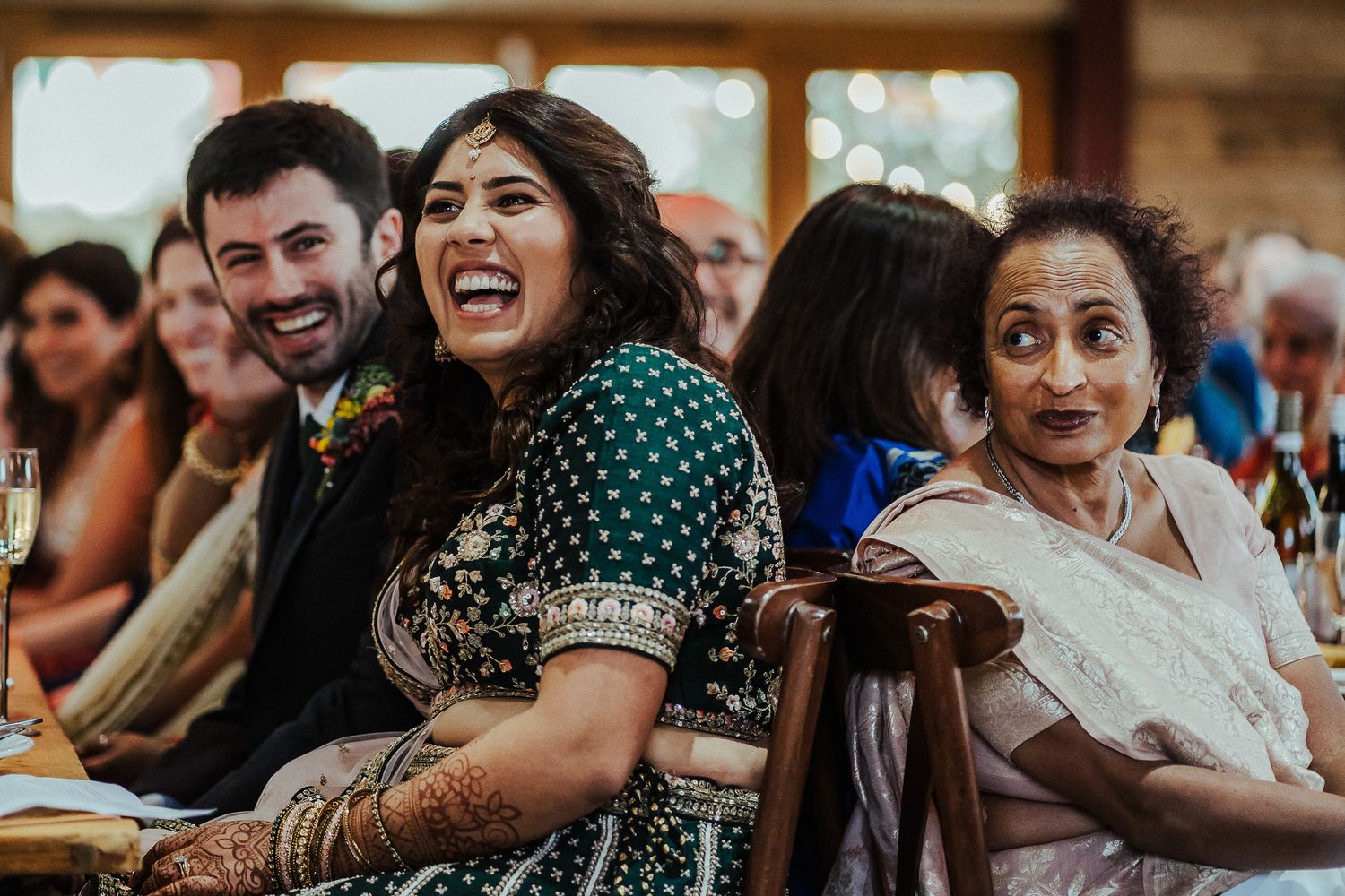 Joyful wedding guests sharing laughter during reception celebrations.