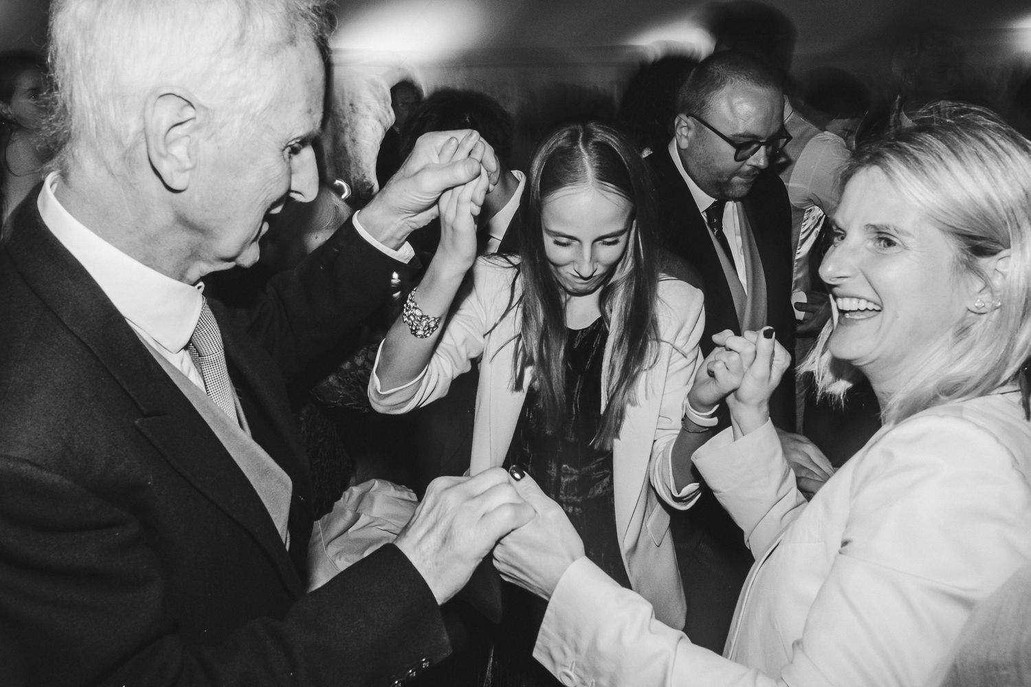 A collection of black and white wedding photos showing couples dancing and celebrating at a reception party.