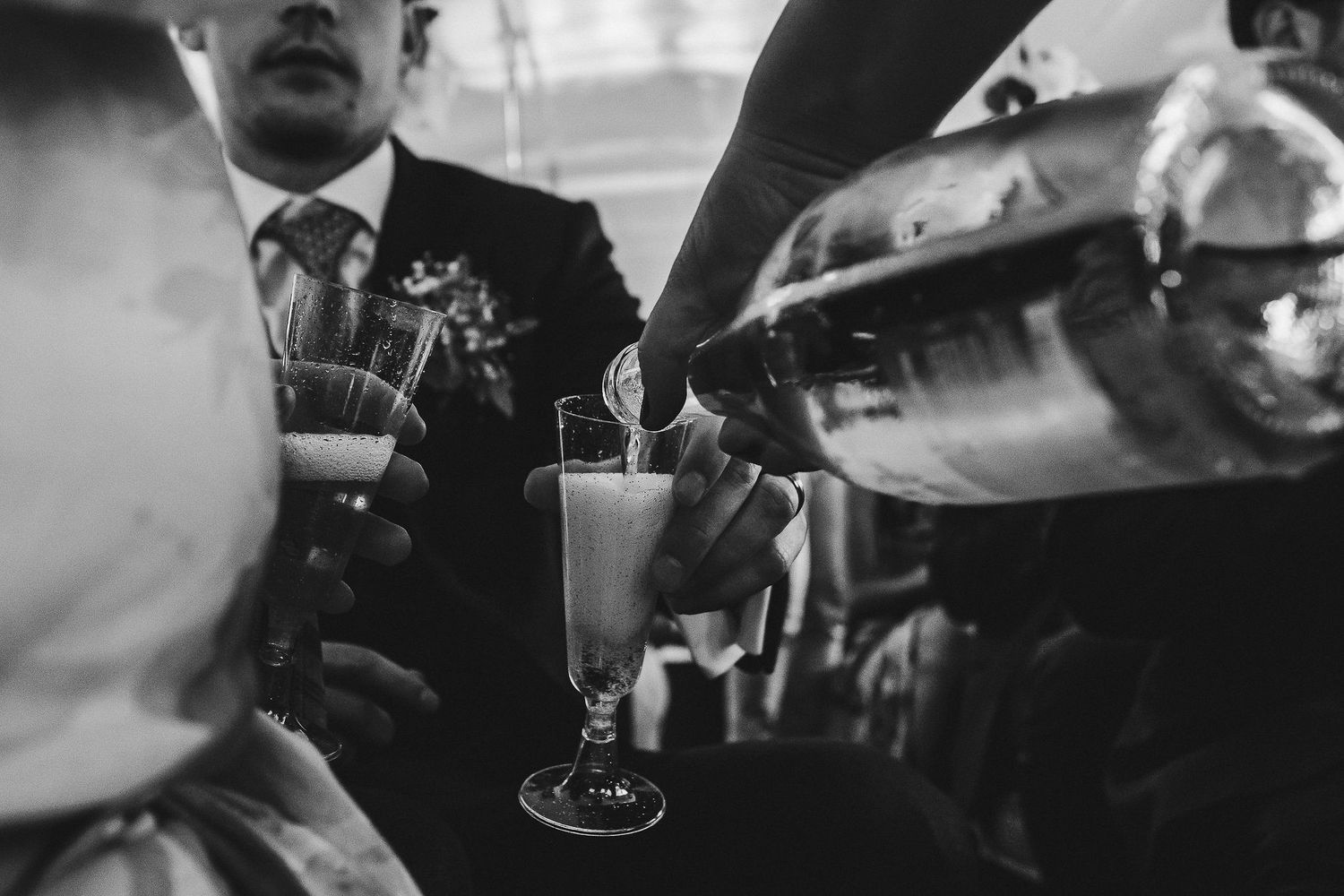 Black and white photo of people dining and drinking at a dimly lit bar with vintage ambiance.