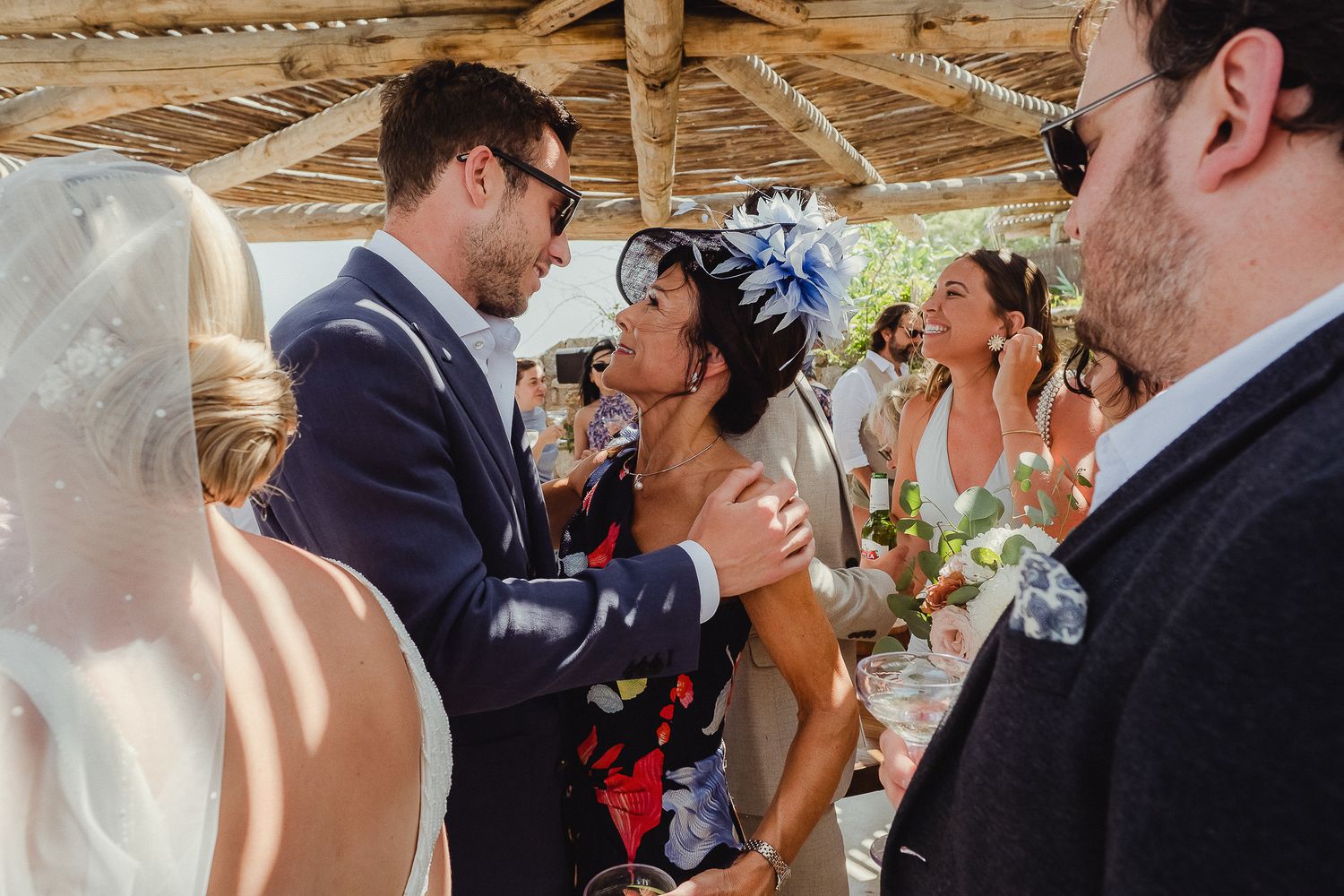Two wedding ceremony participants share an affectionate and joyful moment during an intimate gathering.