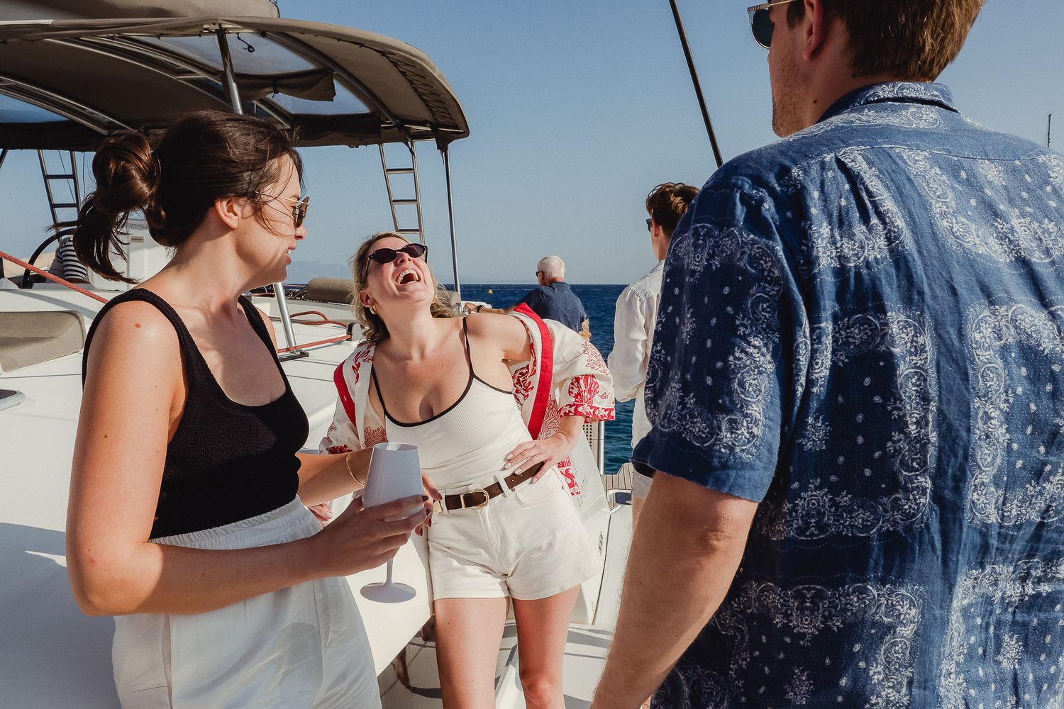 Group celebrating while looking at a massive blue marlin caught during deep sea fishing excursion.