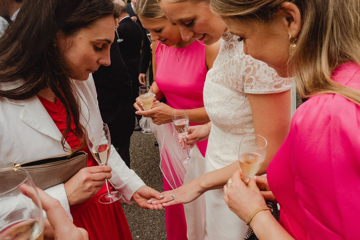 Five people in pink and white outfits enjoying drinks and conversation at a social gathering.