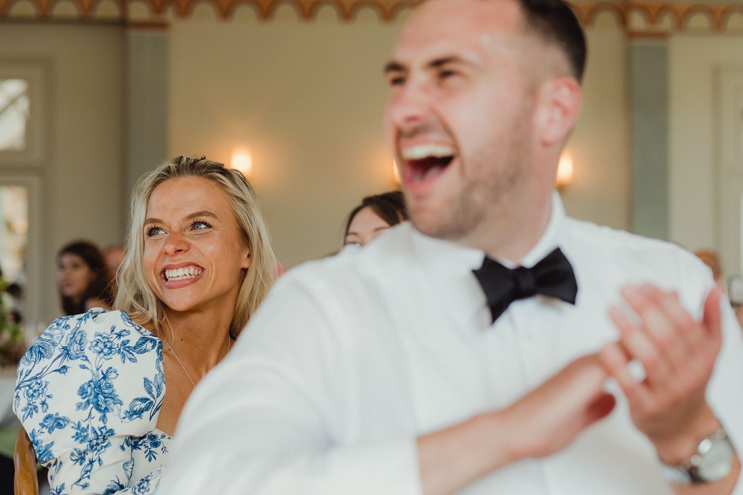 A joyful couple shares a laugh while dancing together at their wedding reception.