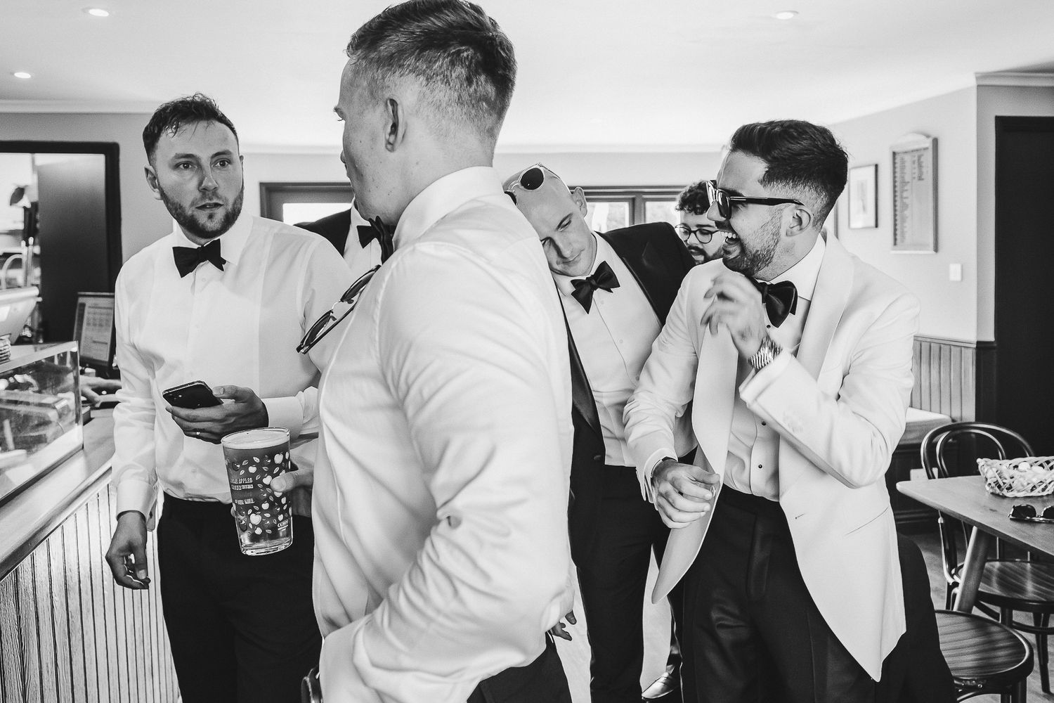 A black and white photo collage shows wedding preparation moments with men in formal attire getting ready.