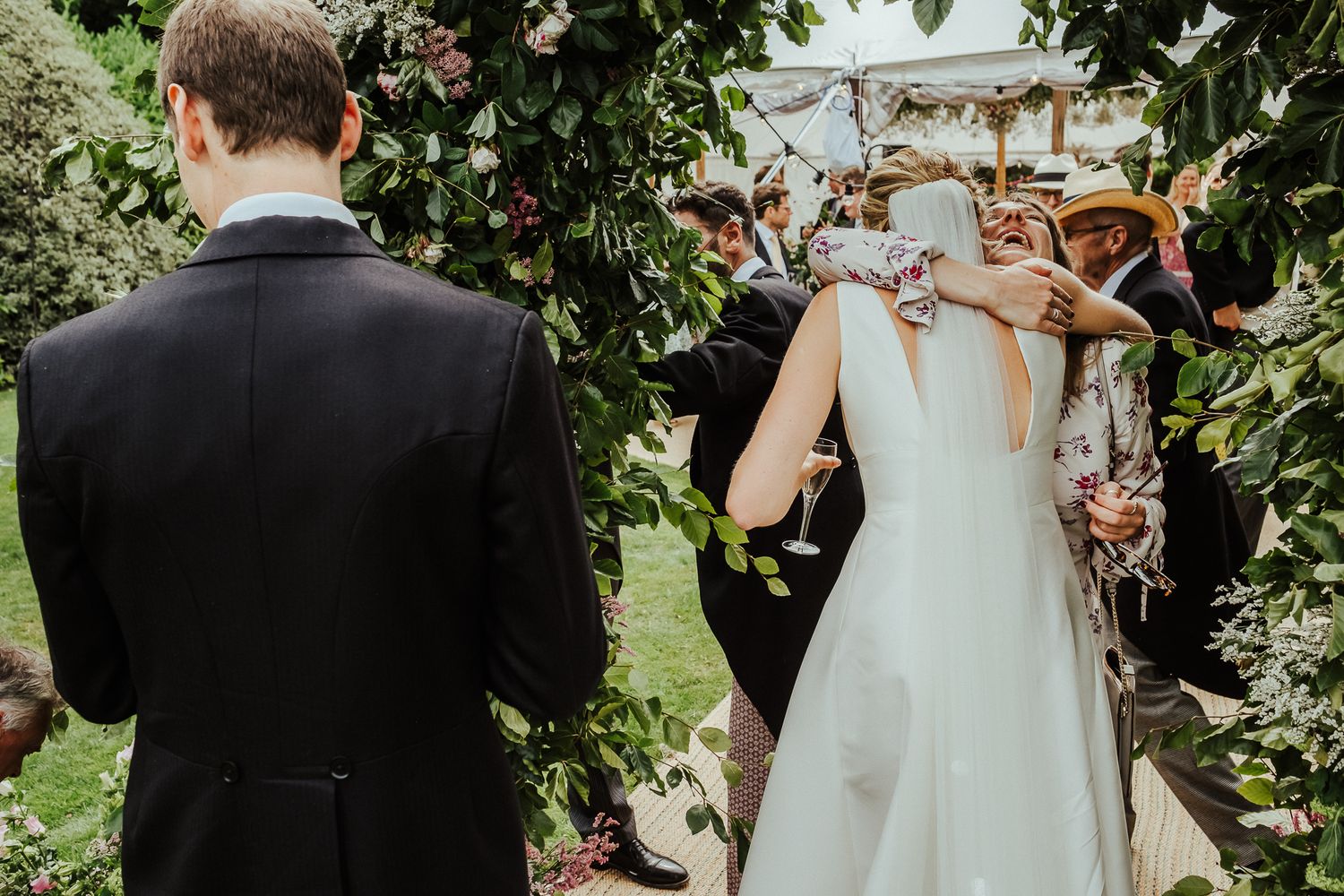 Wedding celebration candid moments captured in a lush garden setting with natural greenery.