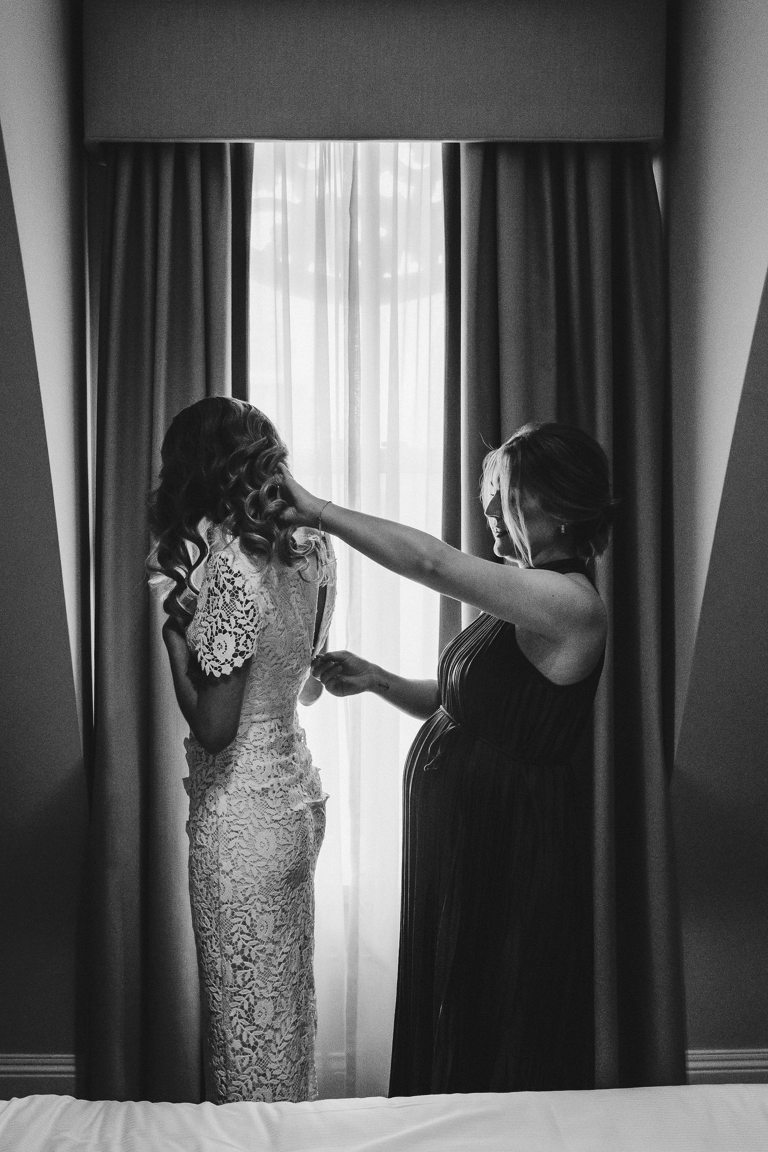 A series of black and white photos showing someone adjusting window curtains in a room.