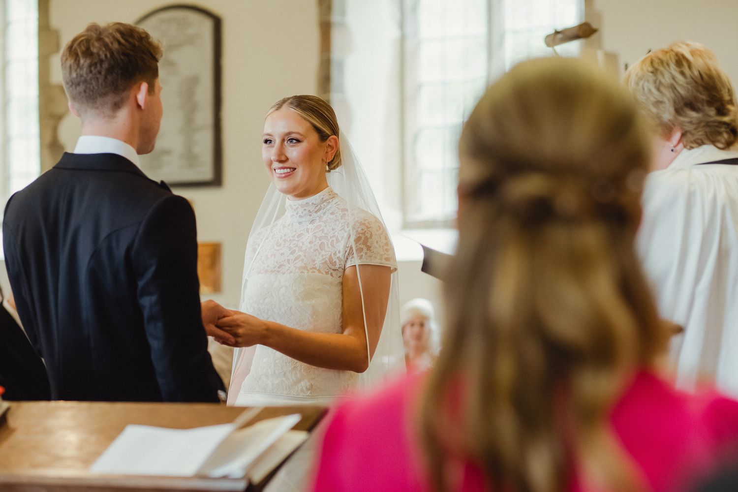 A bride getting ready for her wedding day with hair and makeup being styled in an elegant indoor setting.