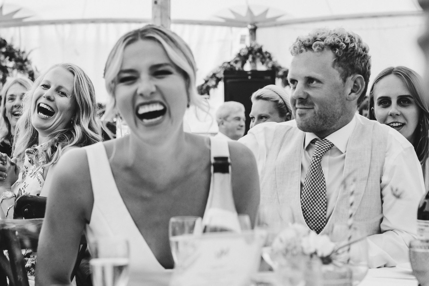 Candid moments of pure joy and laughter captured during wedding reception speeches.