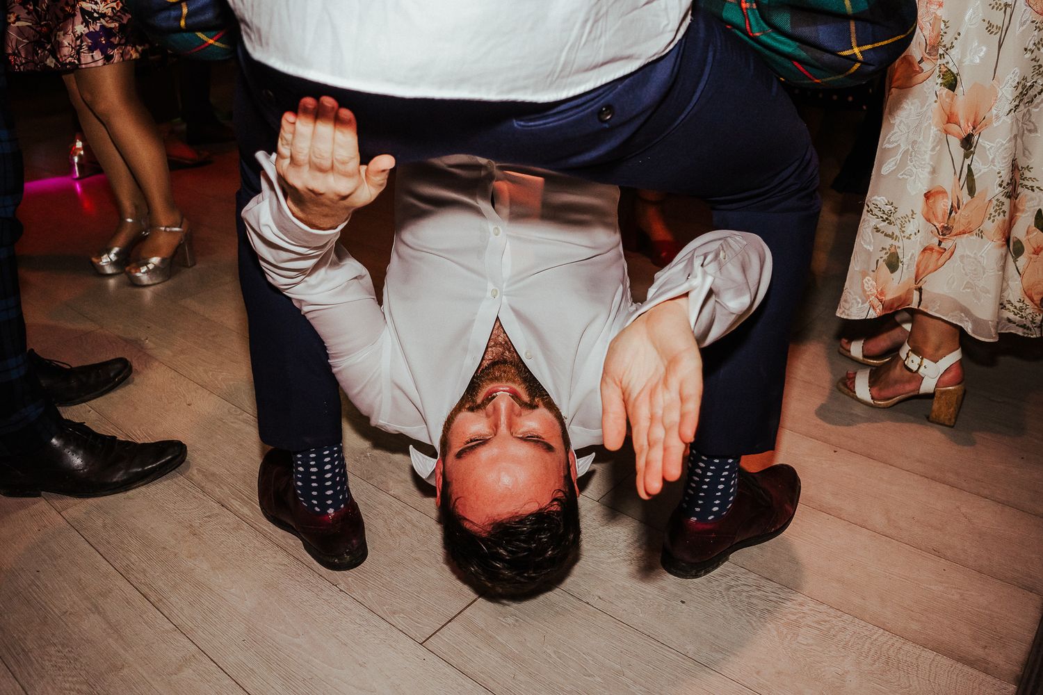 People enjoying themselves dancing on the floor at a nighttime celebration.
