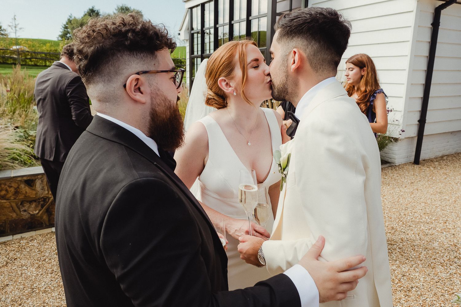 A romantic wedding couple shares tender moments in a series of intimate poses outside a white building.