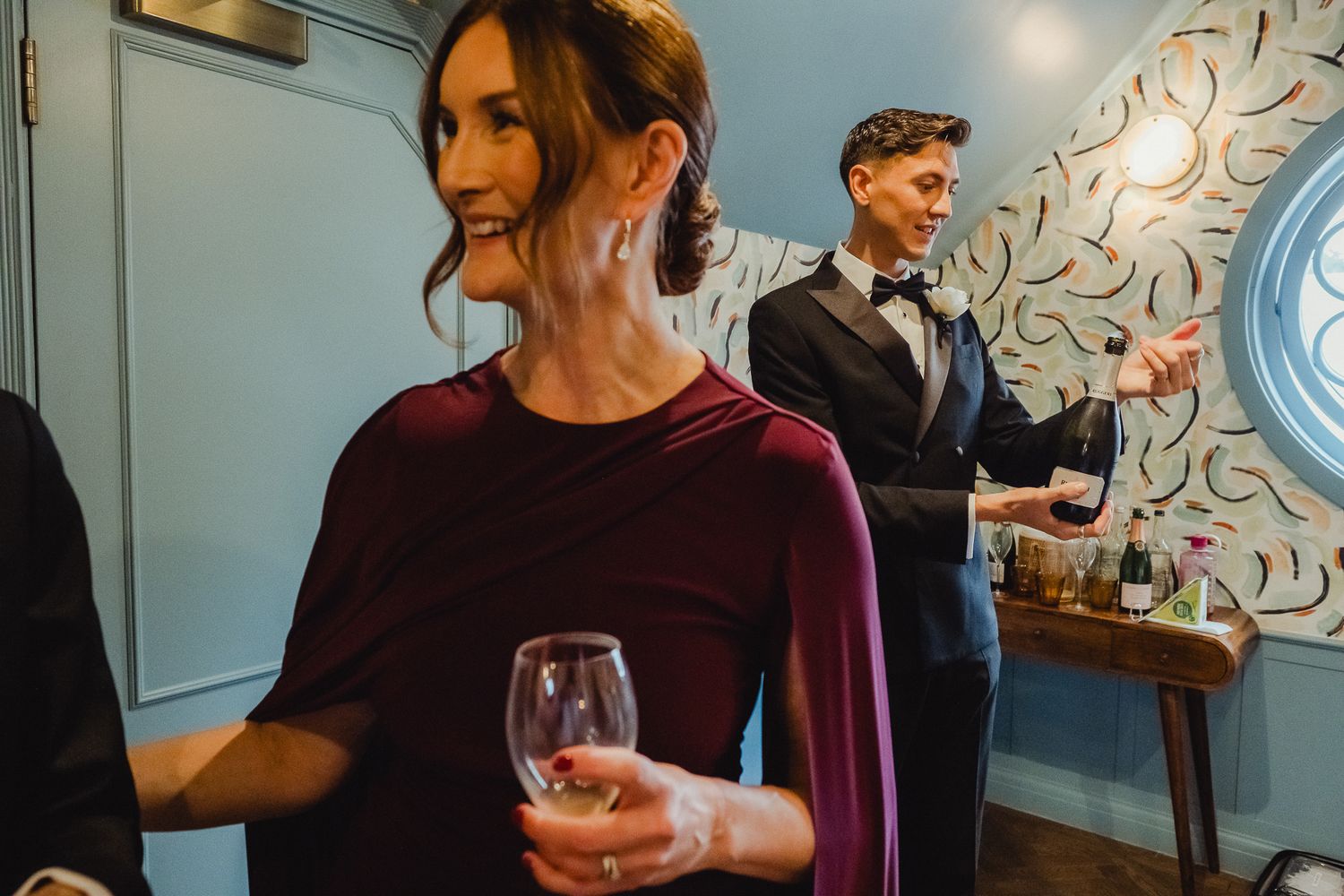 A group of people gather around a table for a wine tasting event in a modern restaurant setting.
