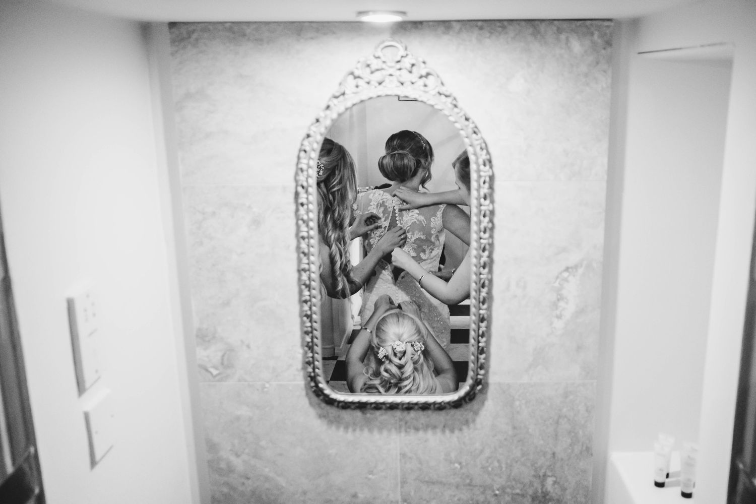 An ornate vintage mirror with decorative floral frame hangs on a white wall.