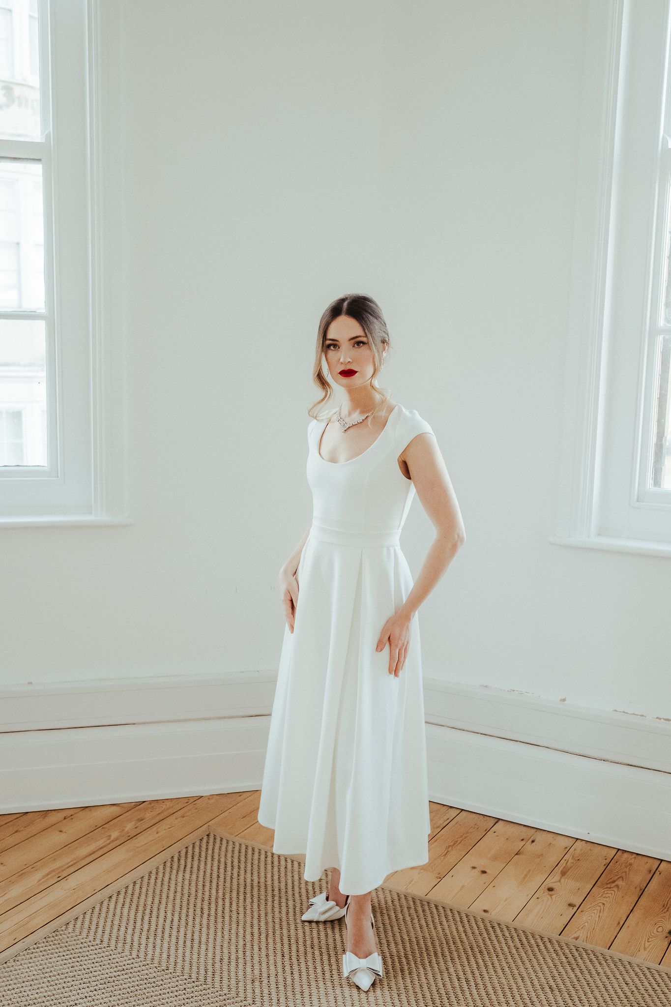 A series of photos showing a person in a white dress posing gracefully against white walls and wooden floors.