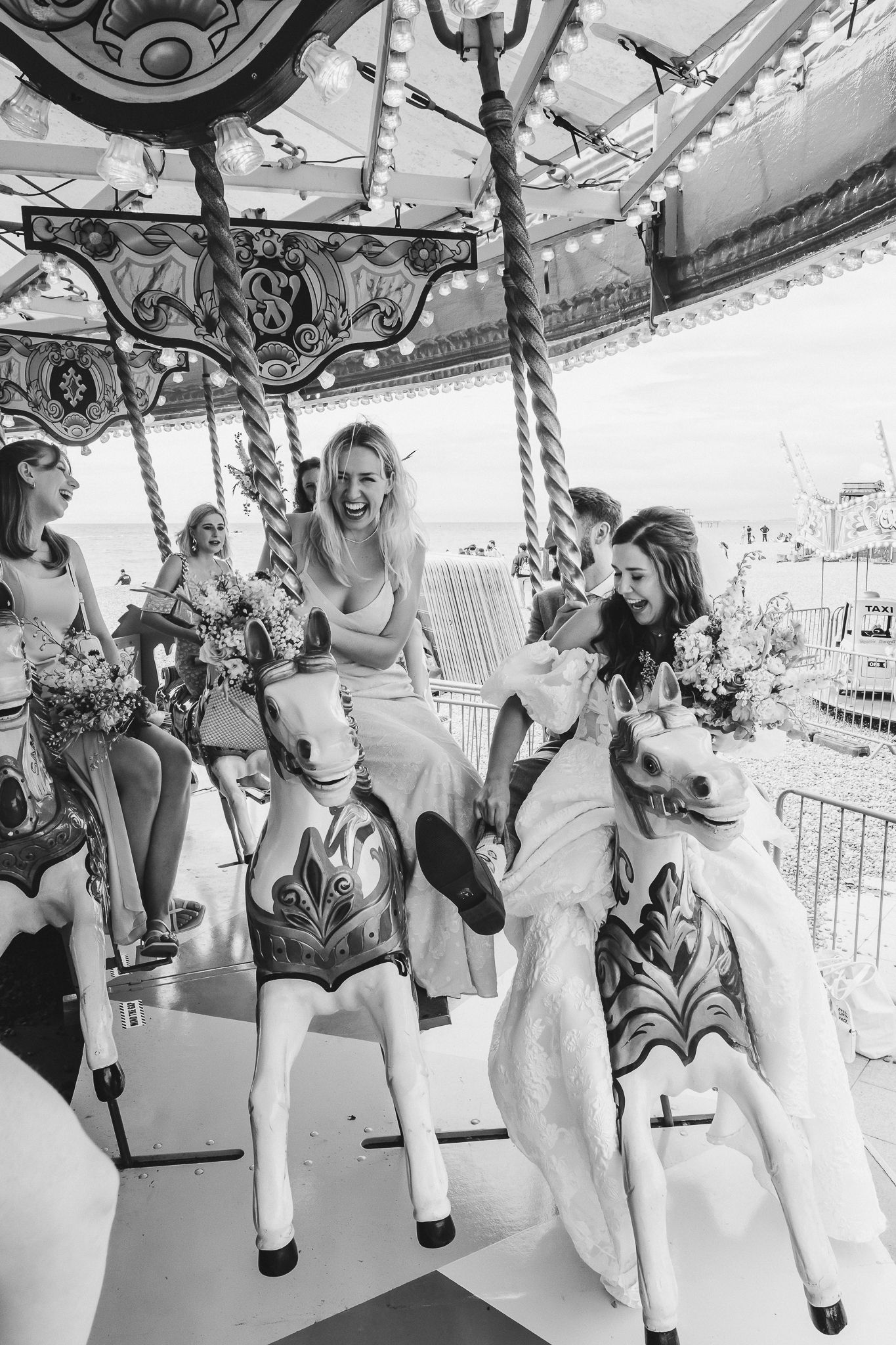 A sequence of black and white carousel photos showing people enjoying rides on decorative horses at an amusement park.