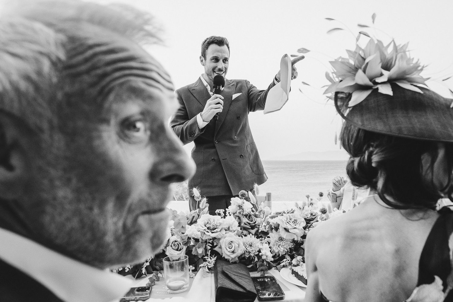 A black and white photo collage shows candid moments at a wedding celebration with guests laughing and toasting.