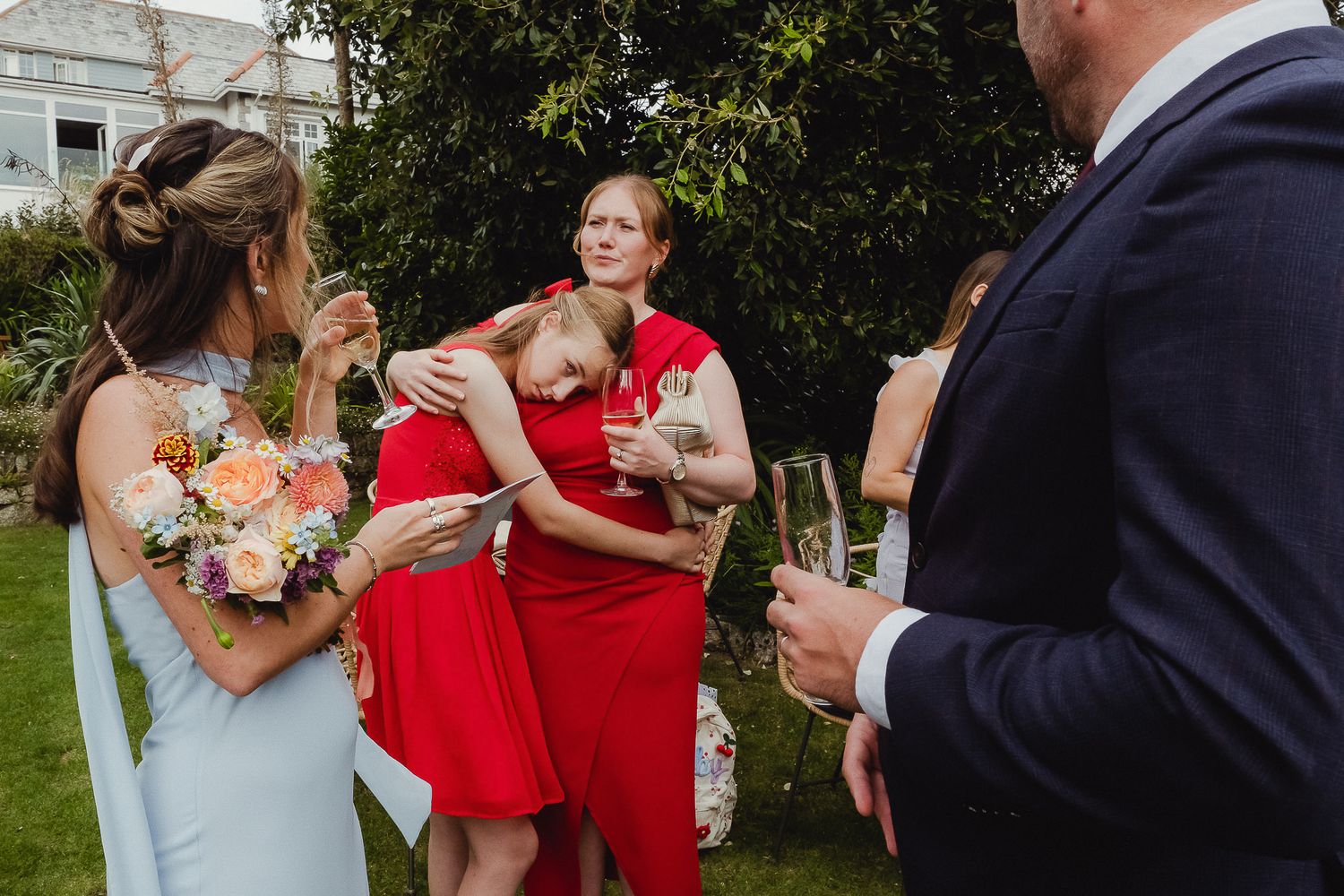 Wedding party members share joyful moments and laughter during outdoor photo session.