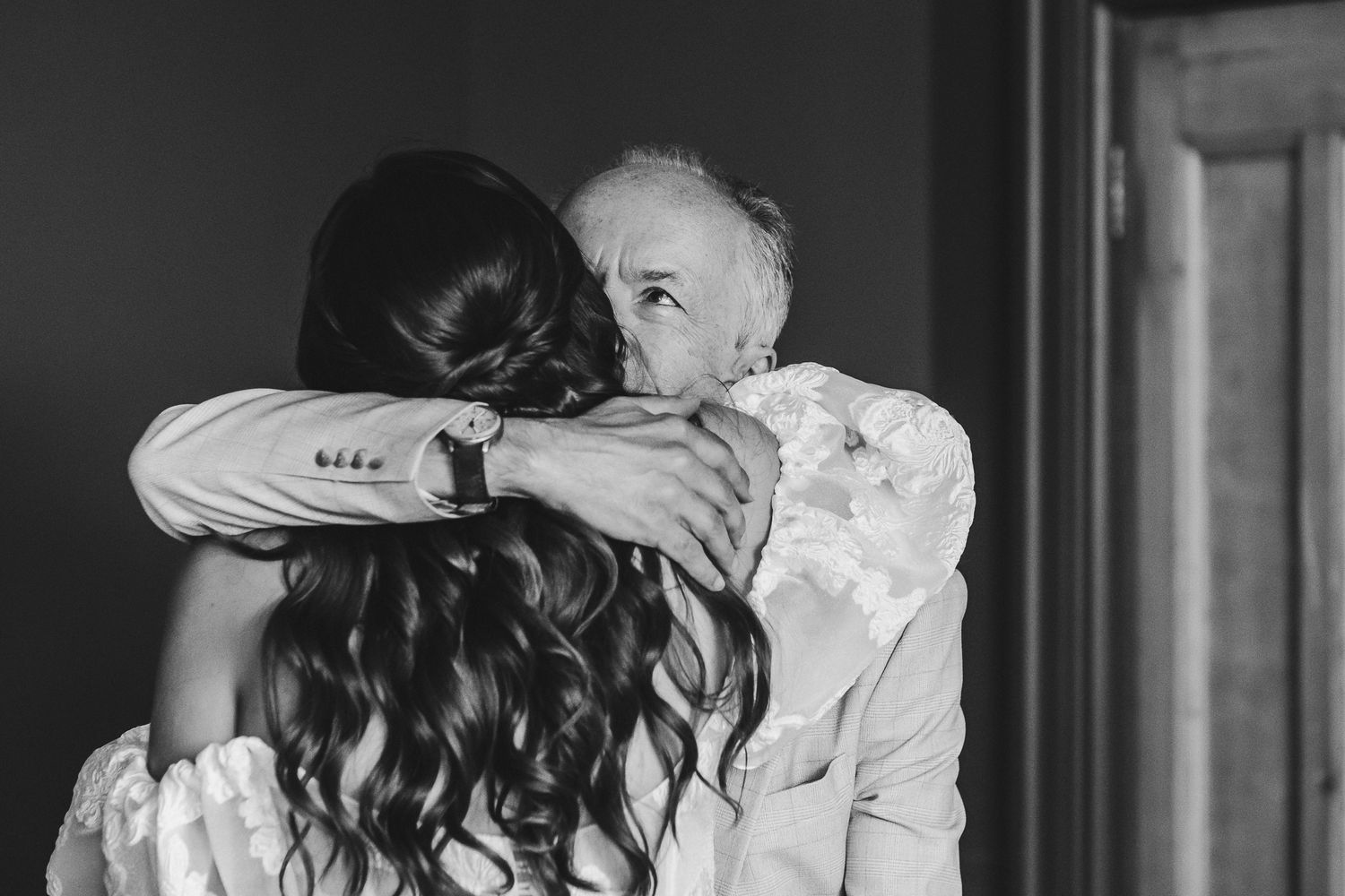 A couple in formal wedding attire share a romantic dance together in an elegant ballroom setting.