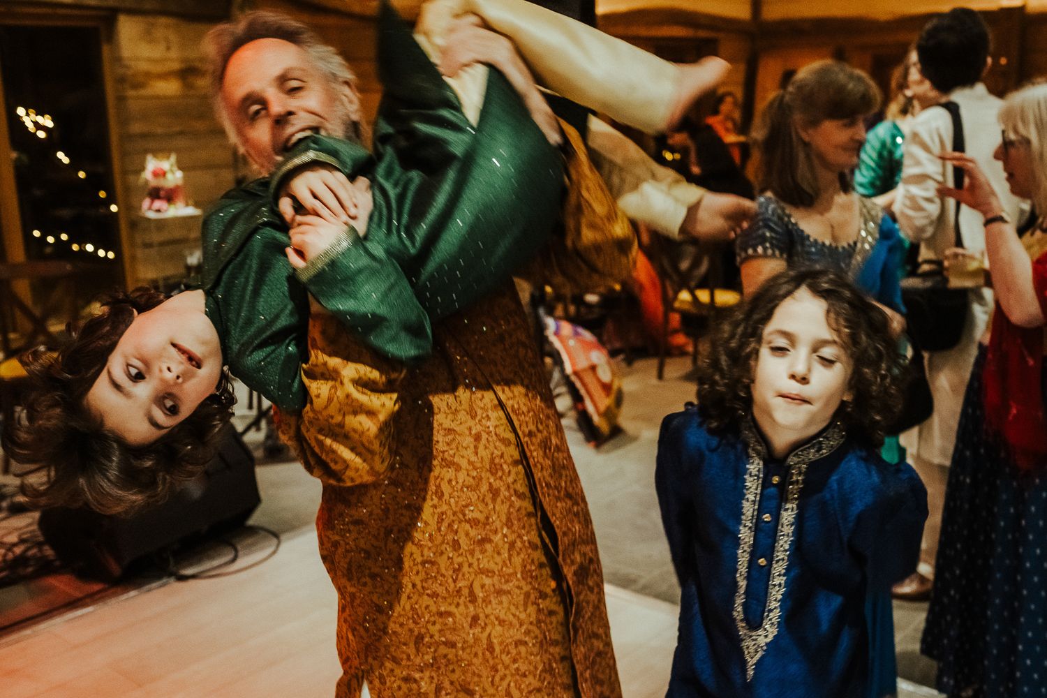 Dancing scene with people in vintage costumes at a rustic indoor venue.