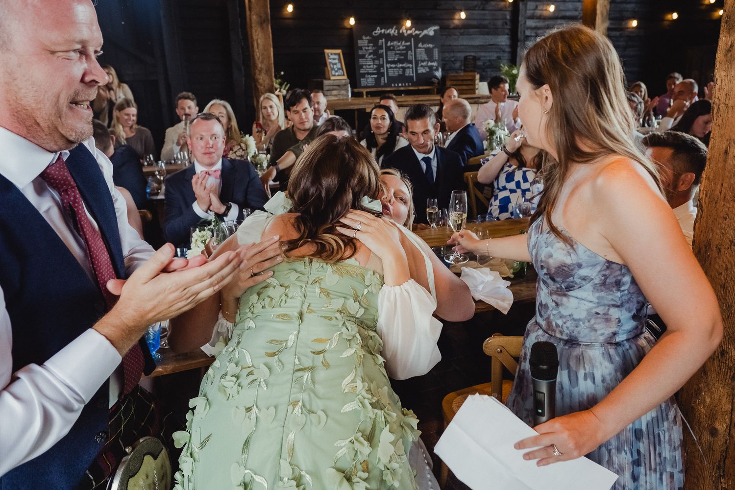 Wedding guests dance together on a lively dance floor during an evening reception celebration.