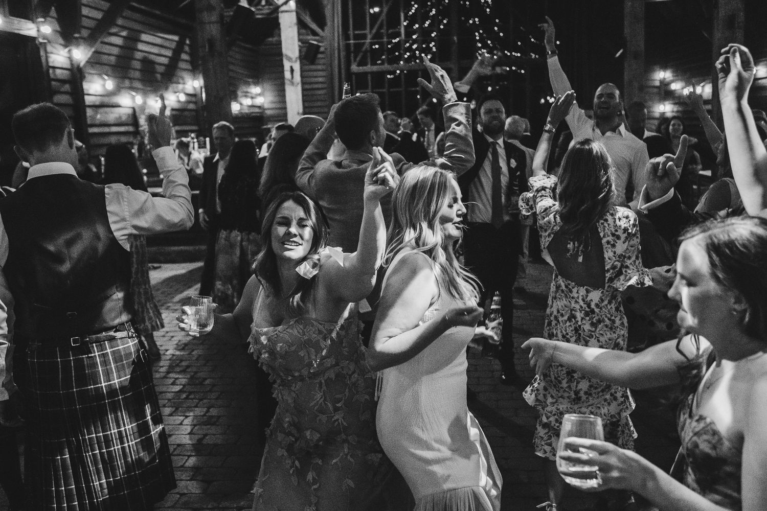 Crowded dance floor at a nightclub with people dancing under colorful lights and a festive atmosphere.