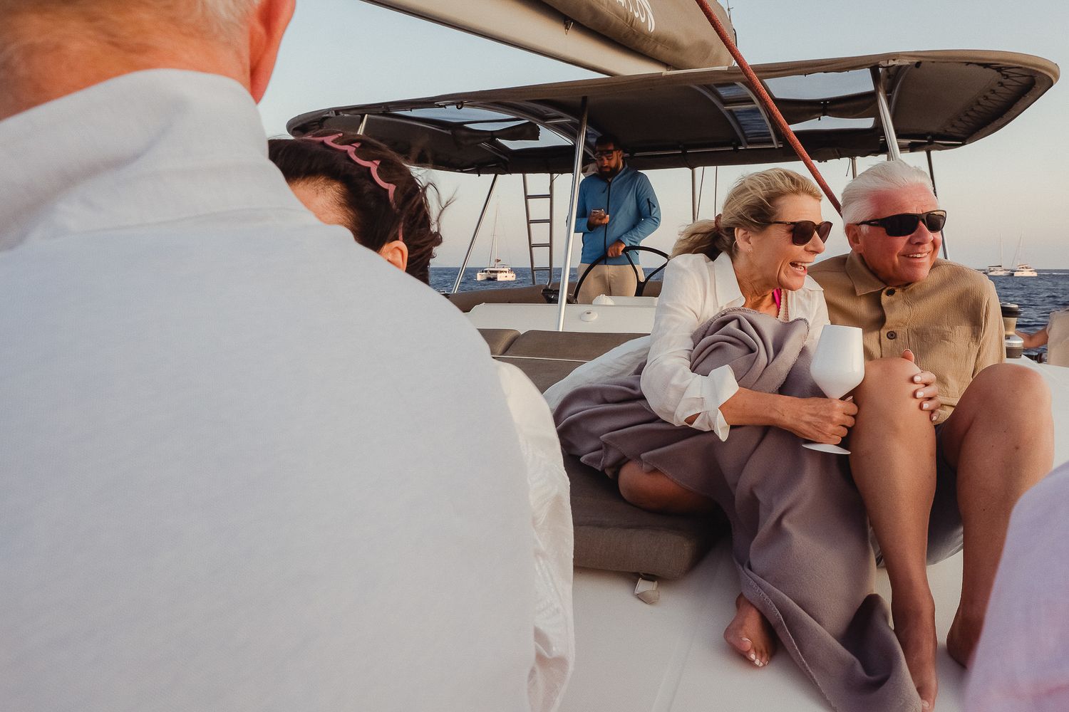 Group of people enjoying a boat trip together, lounging and socializing on a sunny day.