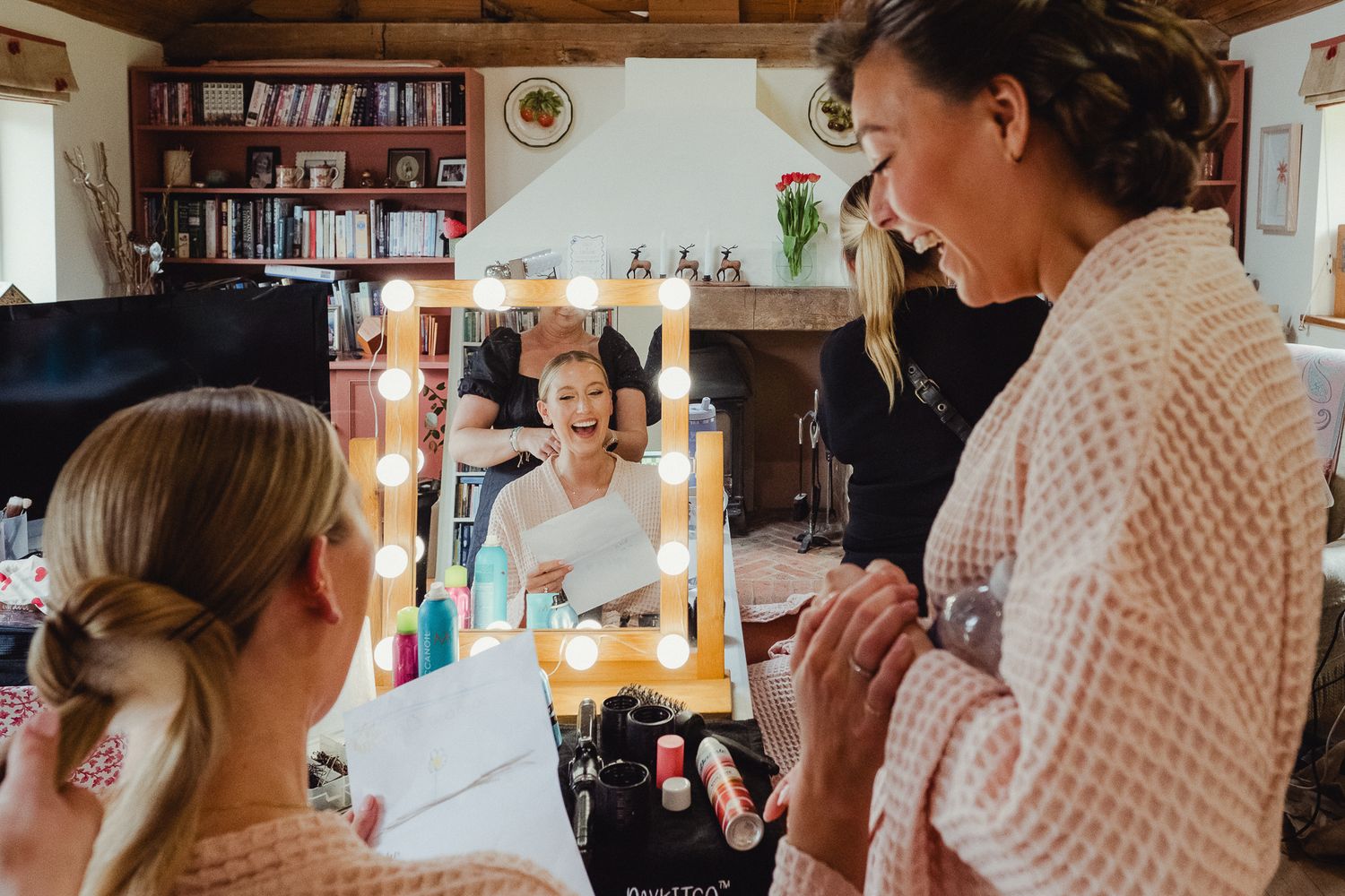 People gathered in a kitchen with candles and warm lighting create a cozy celebratory atmosphere.