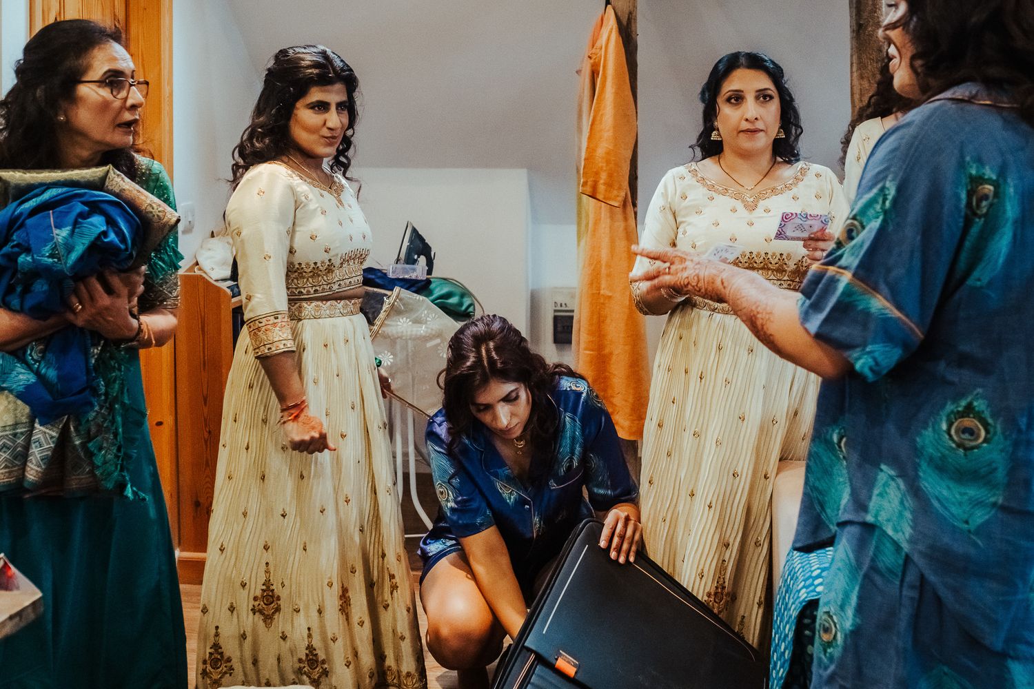 Casual indoor gathering with people wearing mix of casual and traditional attire.