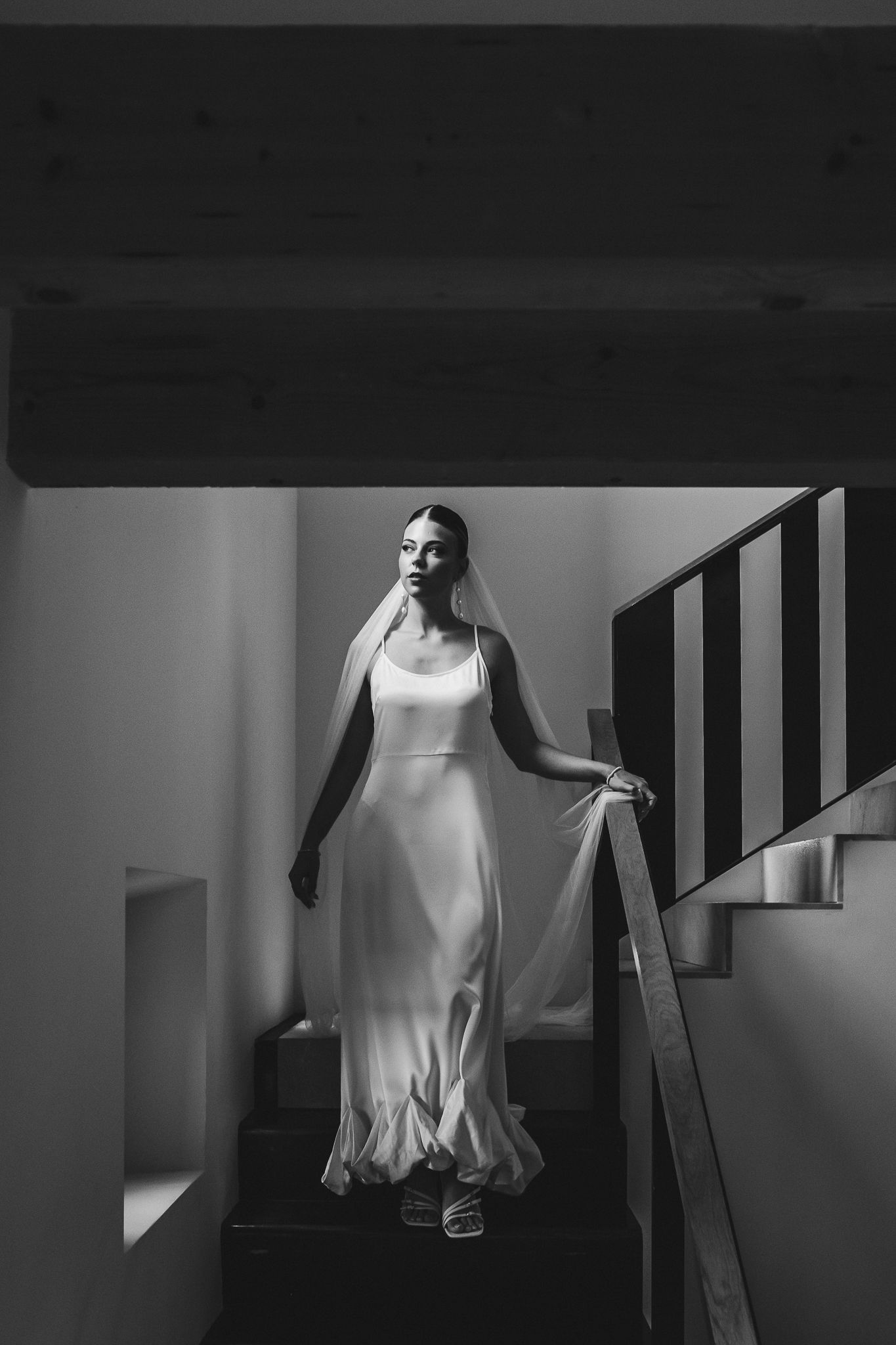 A ghostly figure in a white dress moves mysteriously through a dimly lit stairwell creating an eerie atmosphere.