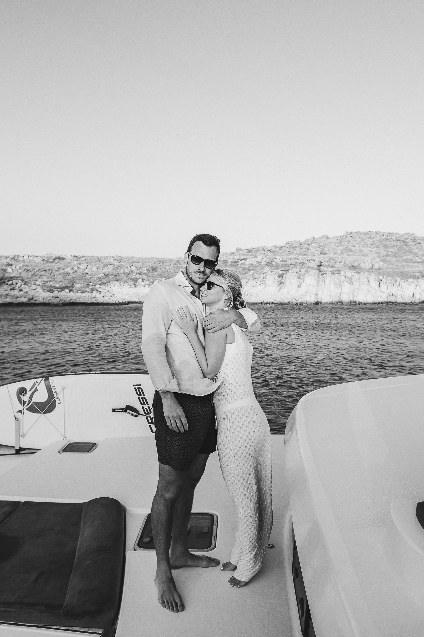 Vintage black and white photo series showing a romantic couple embracing on a boat with desert cliffs in the background.