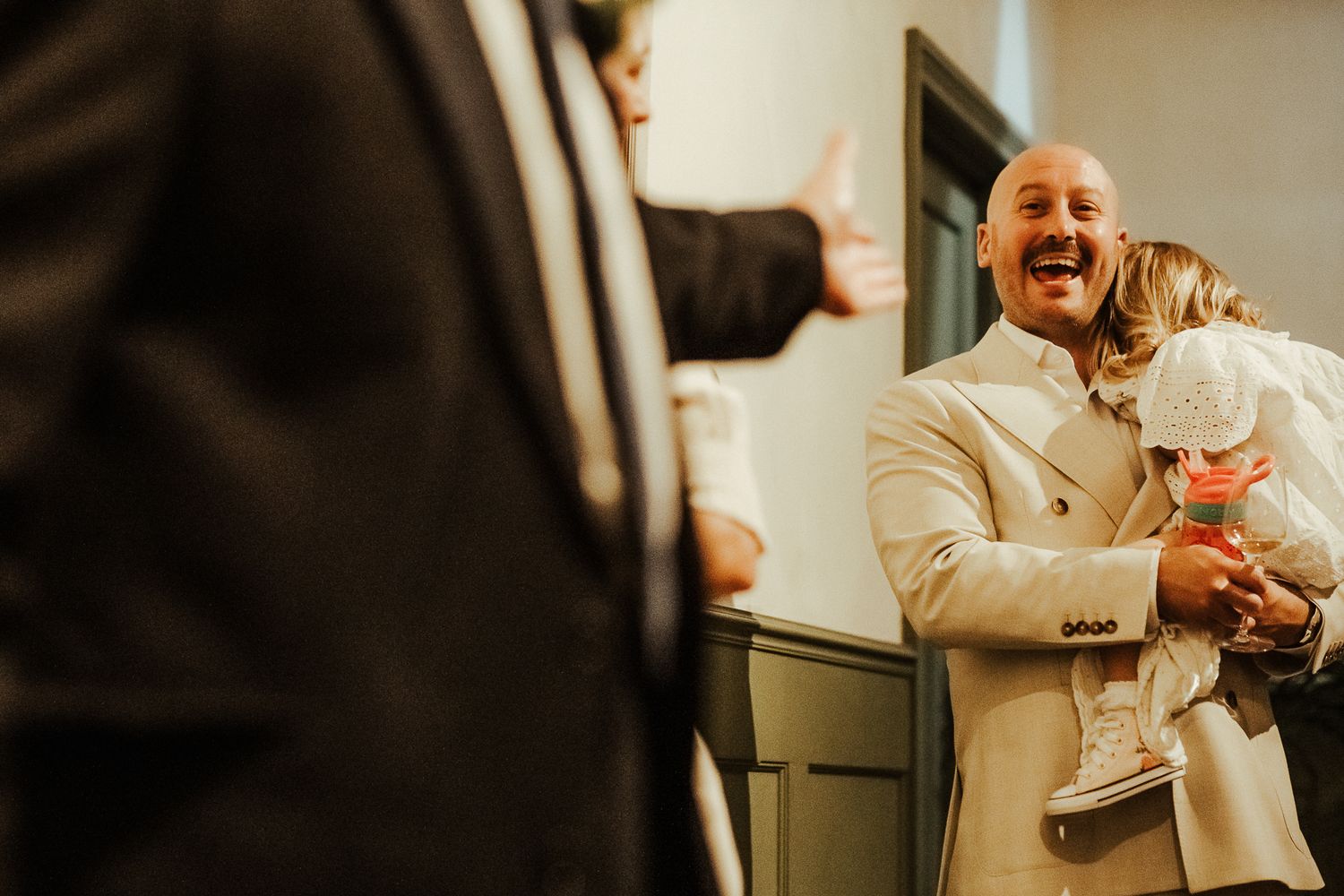 A joyful wedding scene shows a heartwarming moment of laughter between the couple and their small dog during the ceremony.