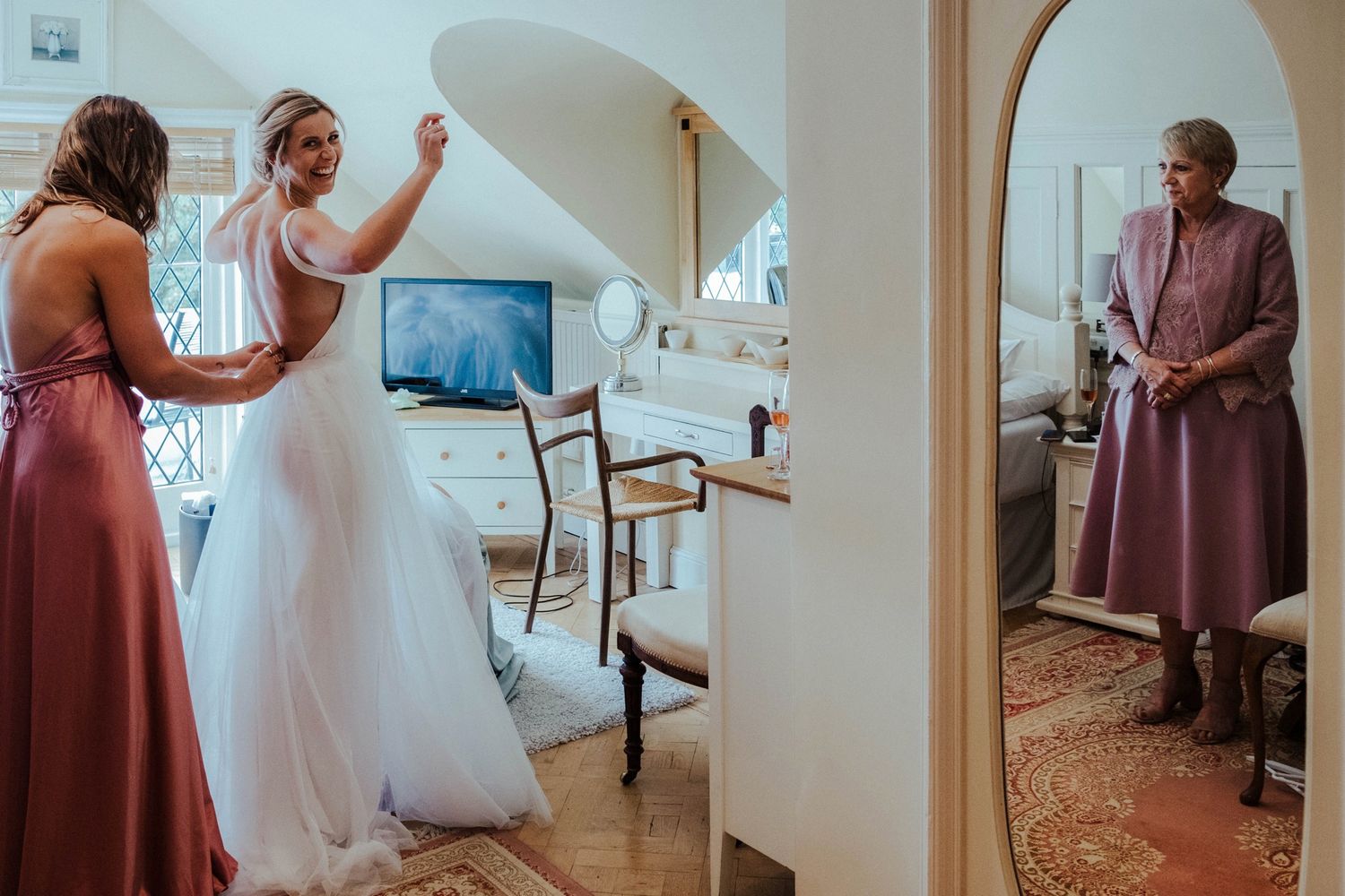 Bridal party getting ready in elegant room with arched doorways.