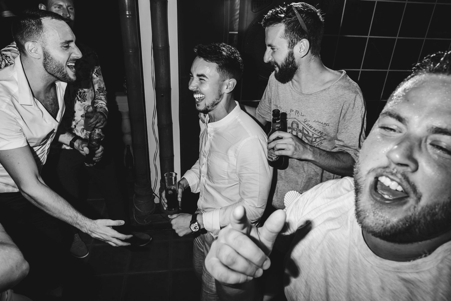 An energetic black and white photo of friends celebrating at a party.
