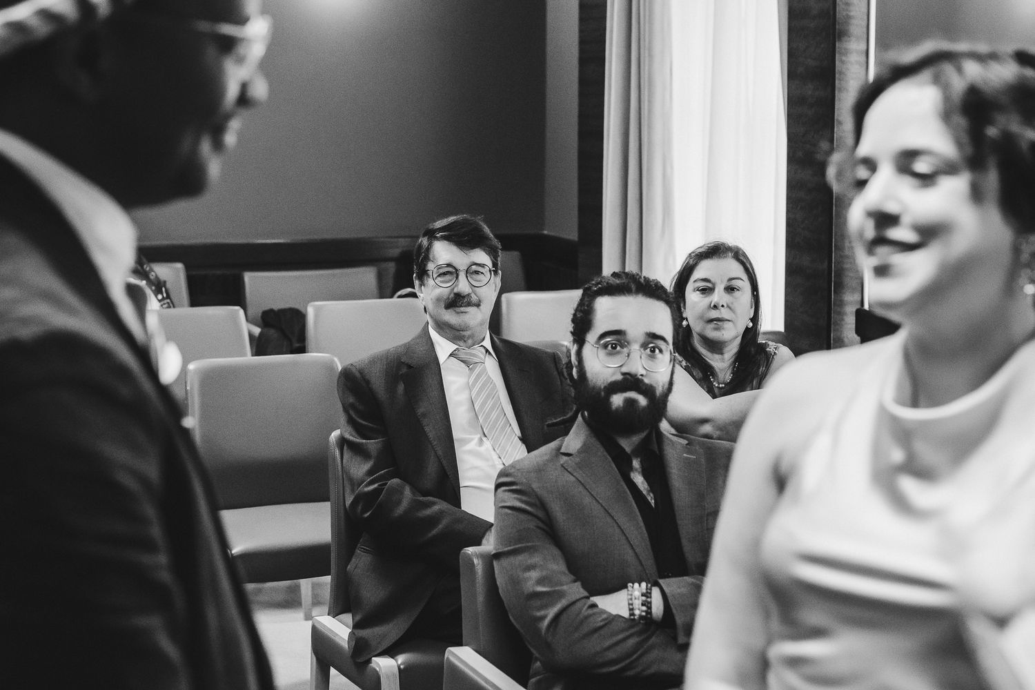 Black and white photo sequence showing candid wedding reception moments with guests laughing and socializing.