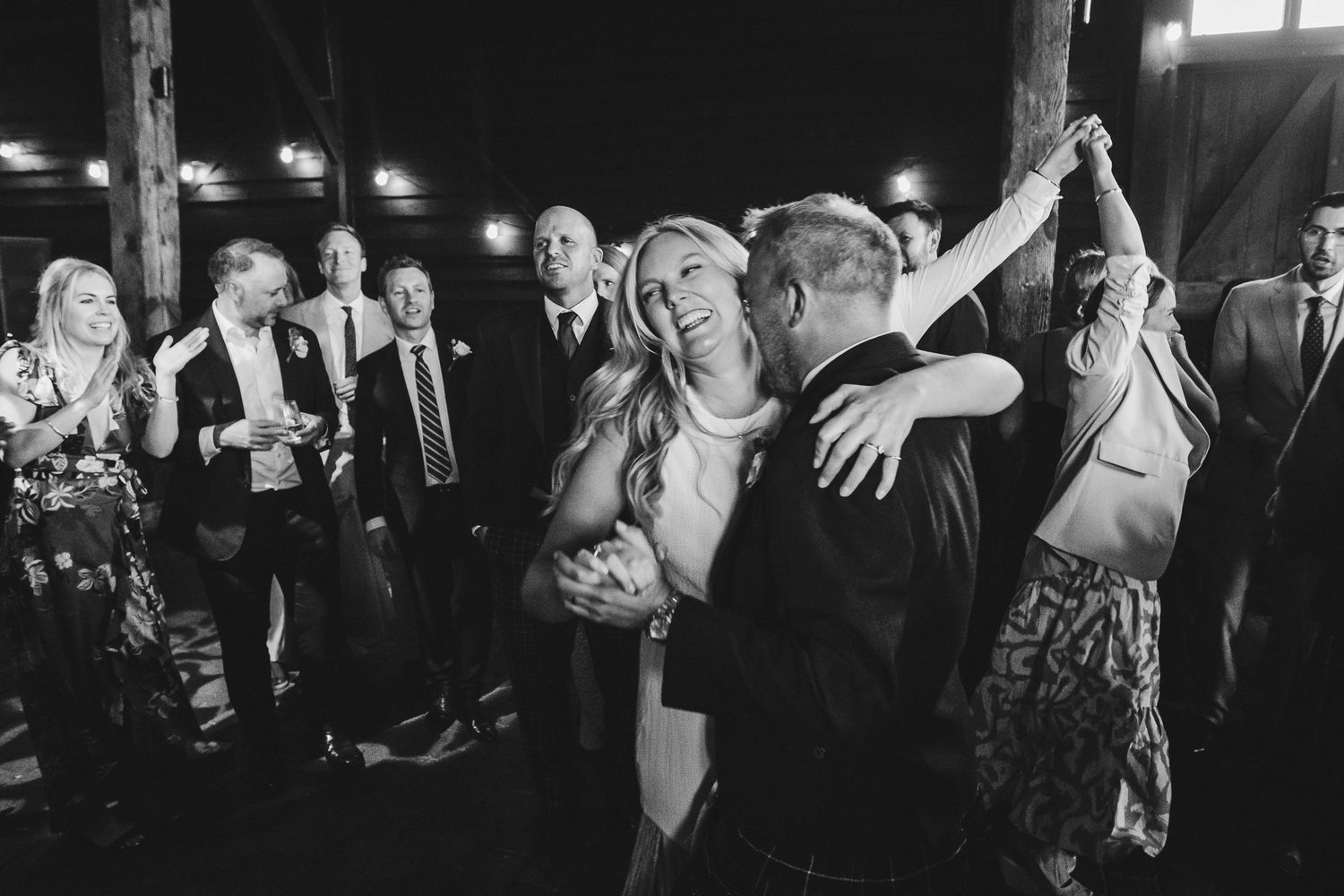 A black and white photo collage showing a crowd of people dancing and celebrating at what appears to be a party or event.