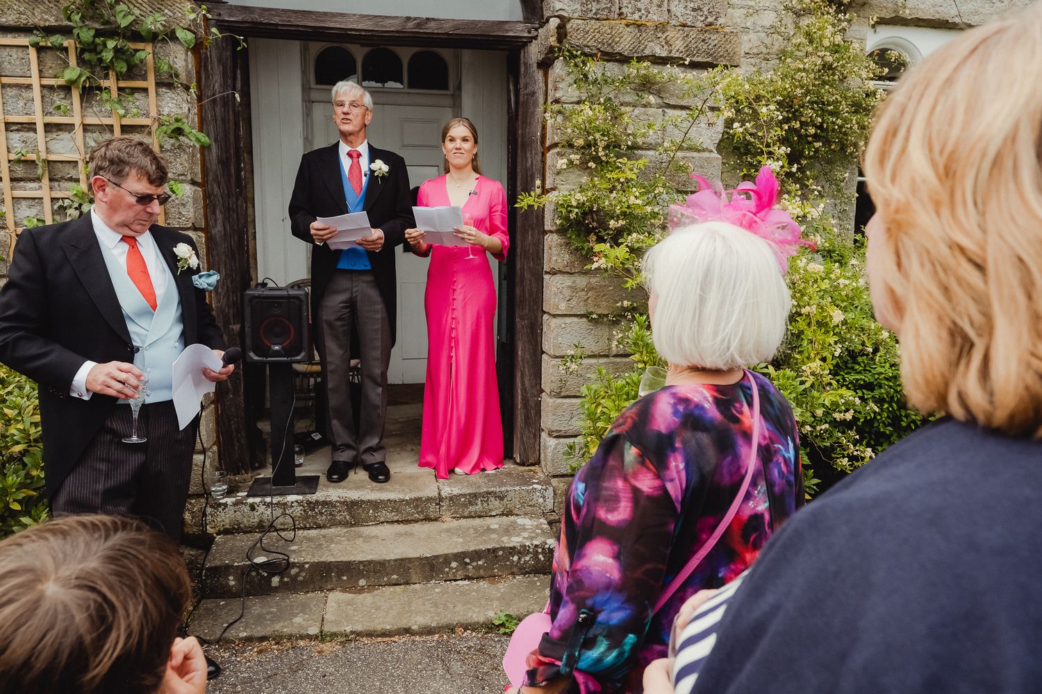 A wedding photographer following a bride and groom while capturing intimate moments in a stone courtyard.