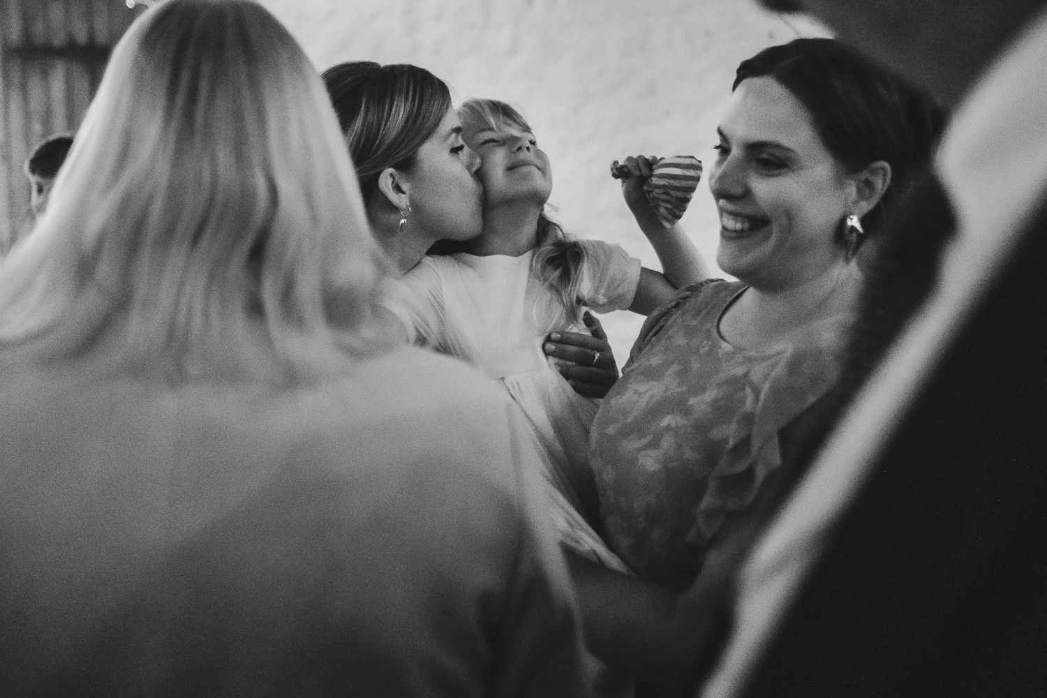 Black and white photo sequence showing candid moments of people laughing together at a social gathering.